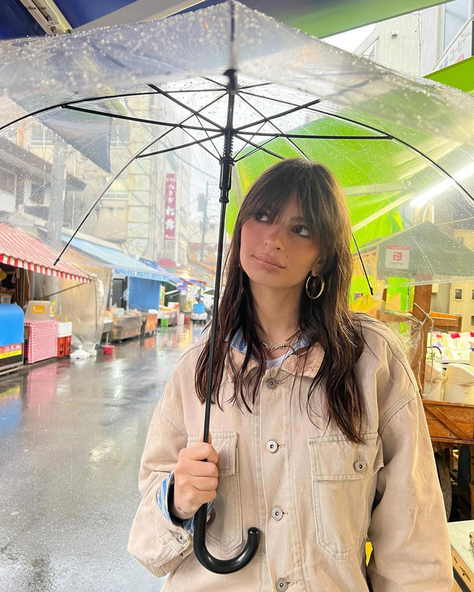 Emily Ratajkowski holding an umbrella.