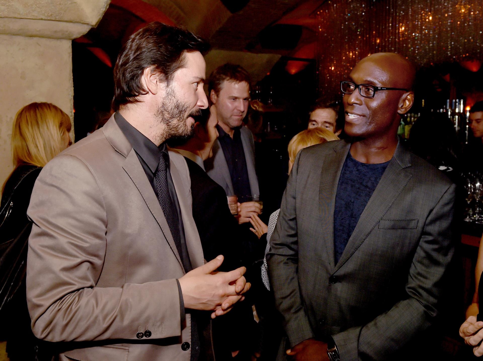 Lance Reddick speaking with Keanu Reeves.