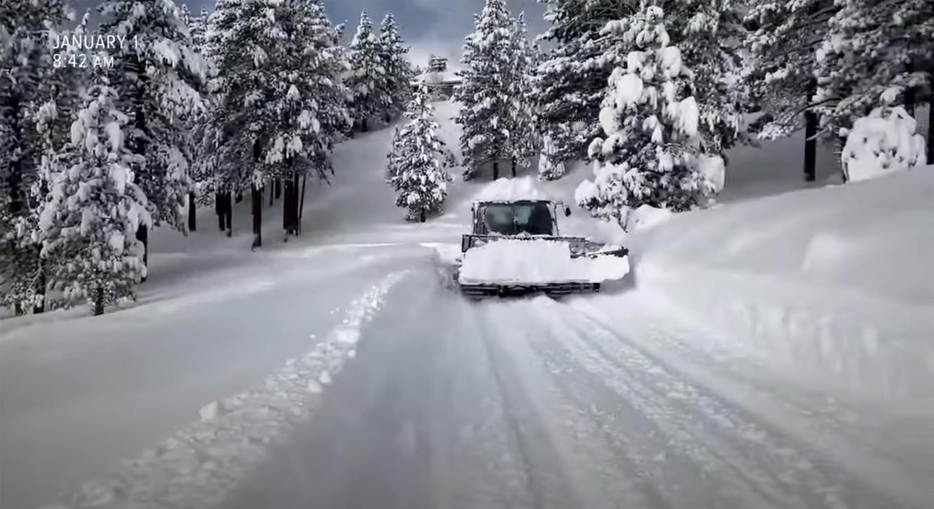 a snow plow driving on a snow-covered road