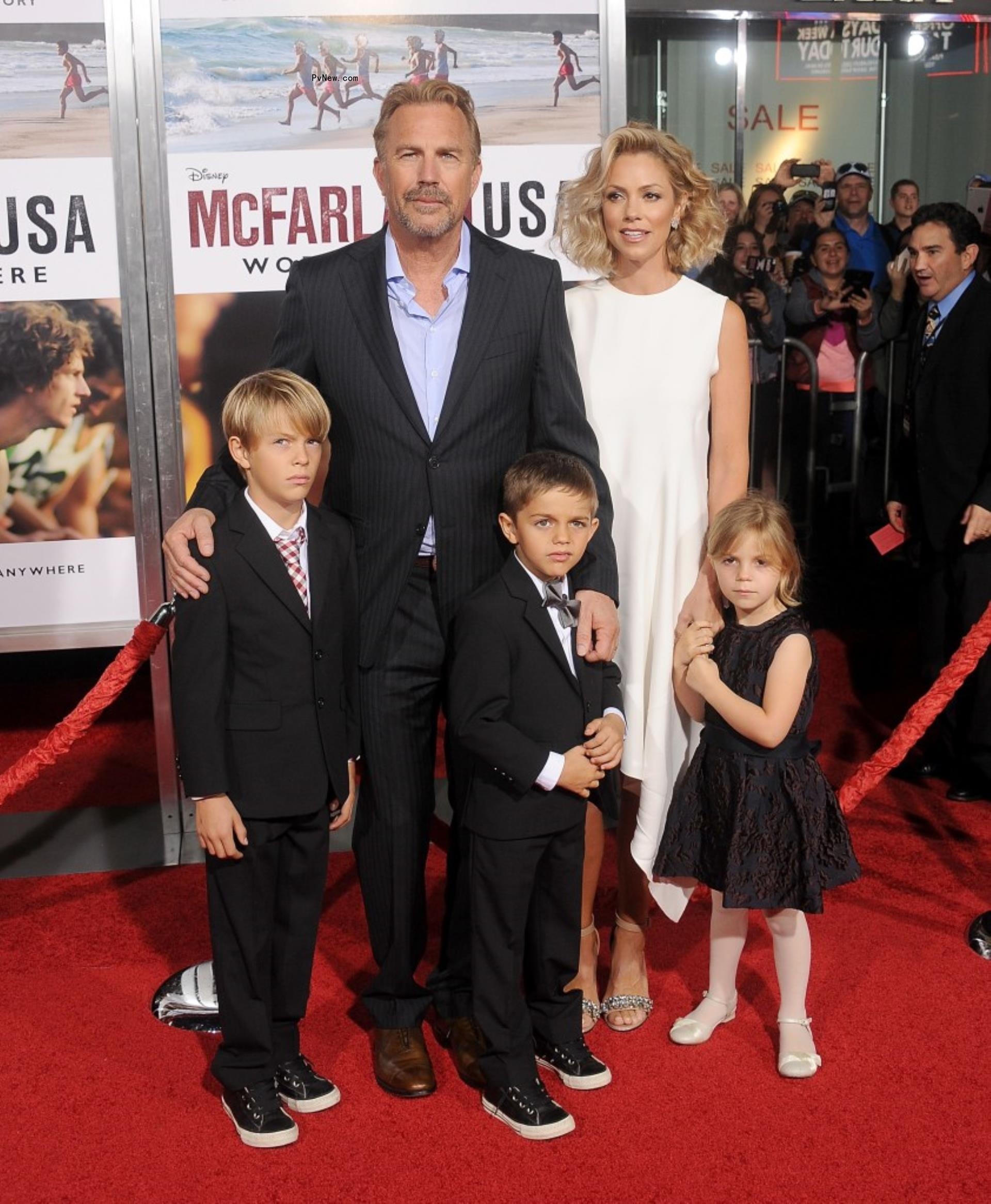 kevin costner, christine baumgartner and their two sons and daughter on a red carpet