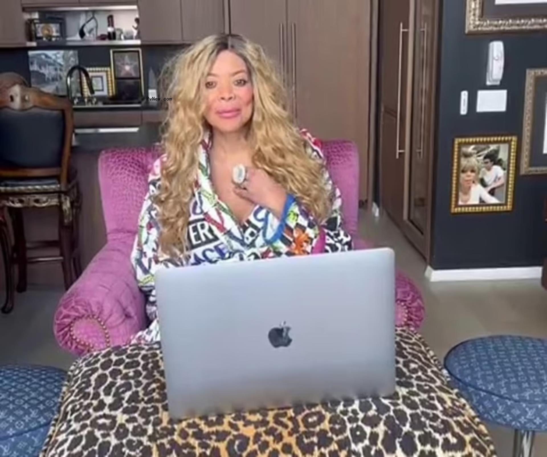Wendy Williams sitting behind her laptop sitting in pink chair.