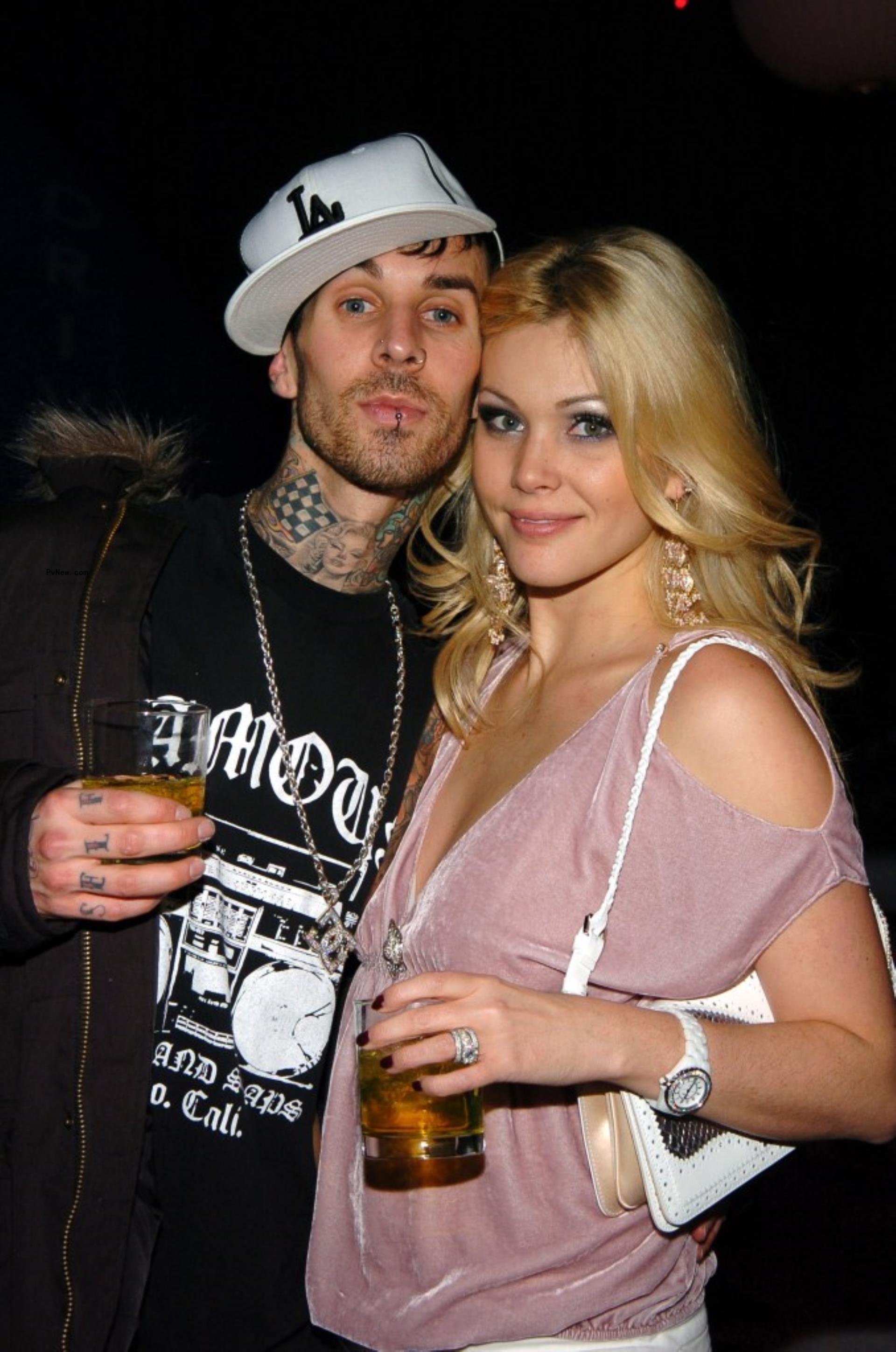 Travis Barker and Shanna Moakler smiling at a party.