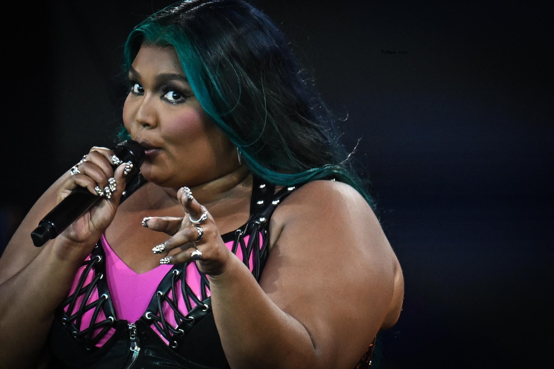 Lizzo pointing while singing onstage.