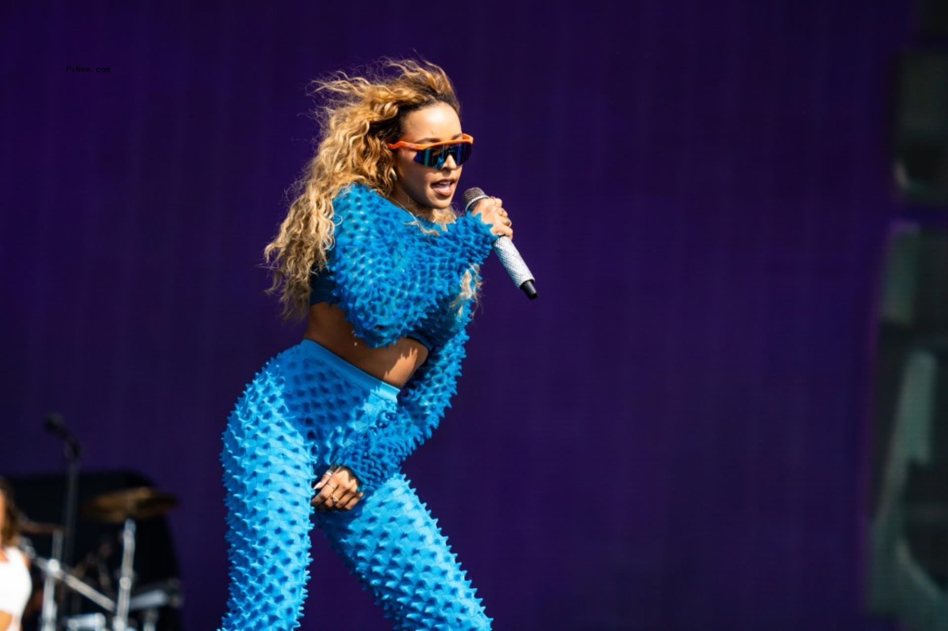 Tinashe performing in blue on stage.