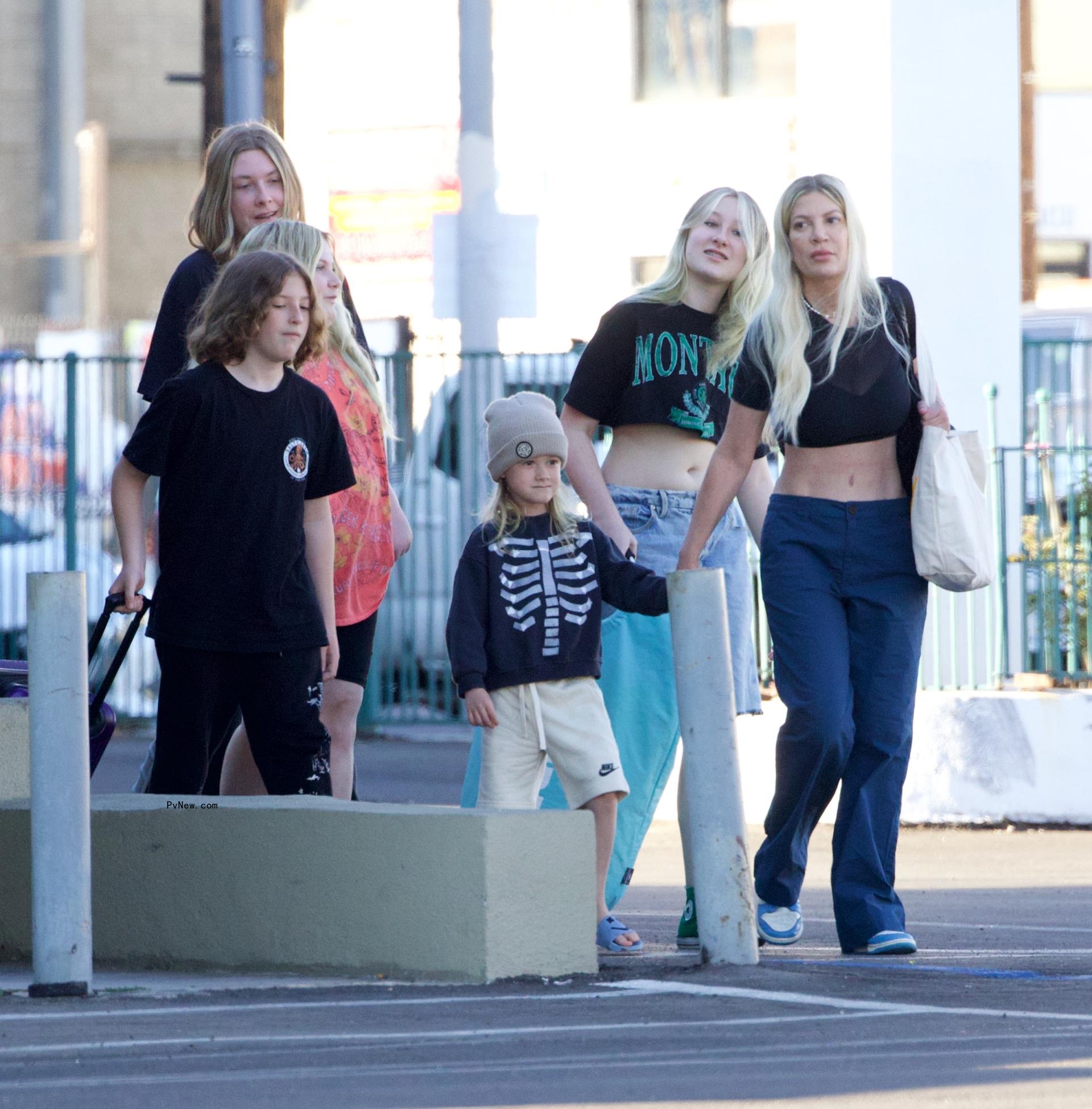 Tori Spelling and her kids leaving a motel.