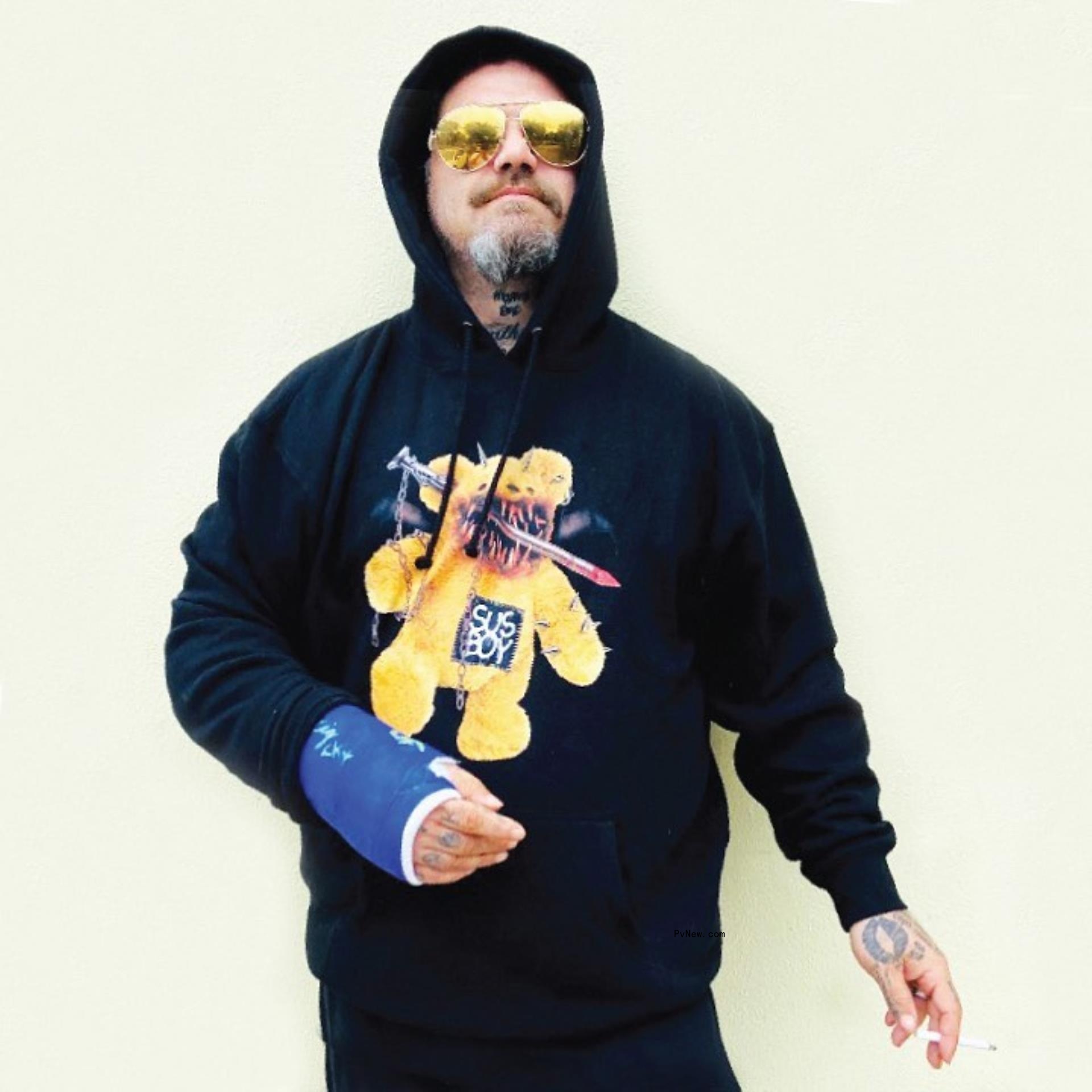 Bam Margera posing in front of a wall