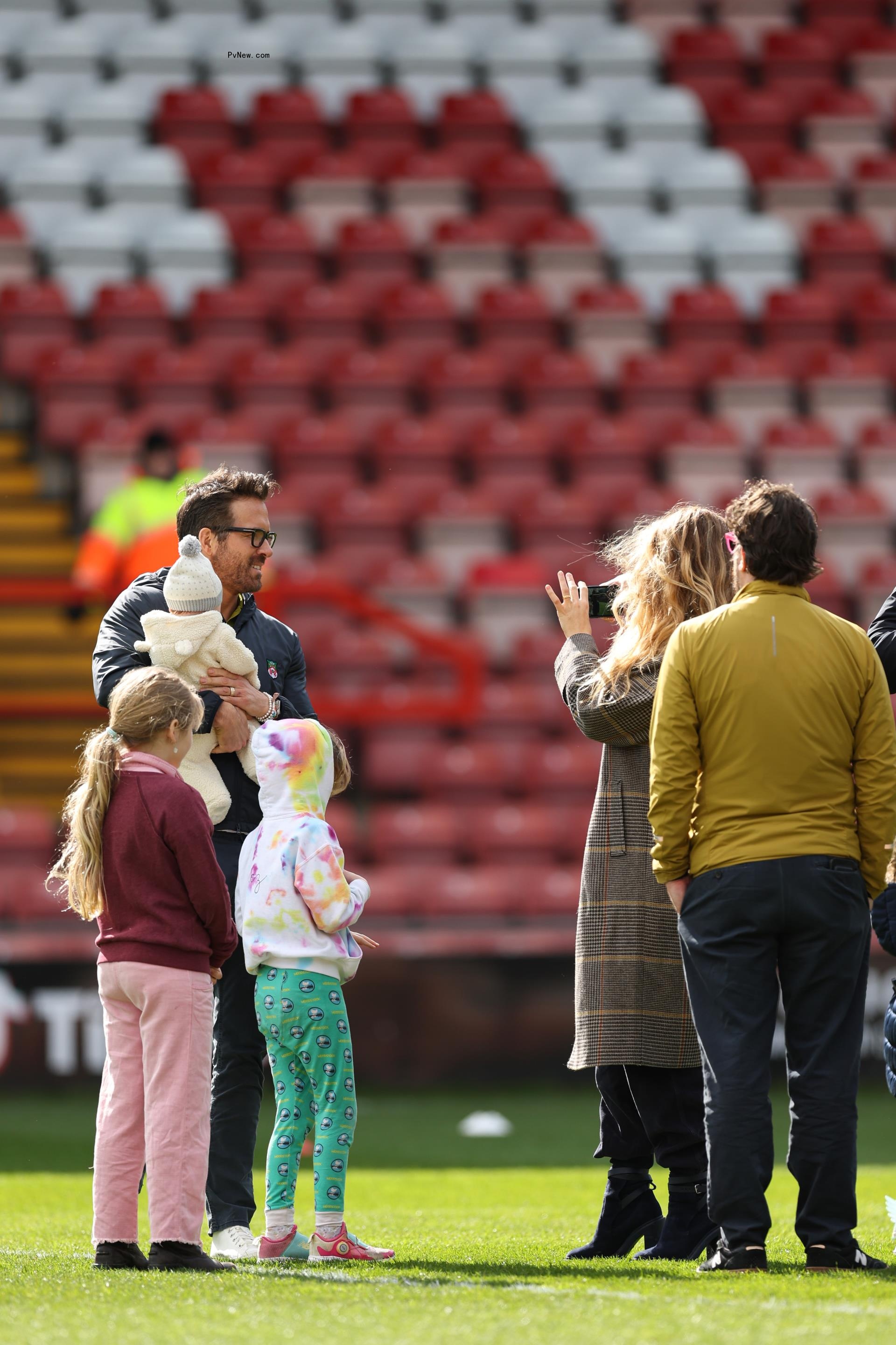 Ryan Reynolds stands on soccer field with daughter