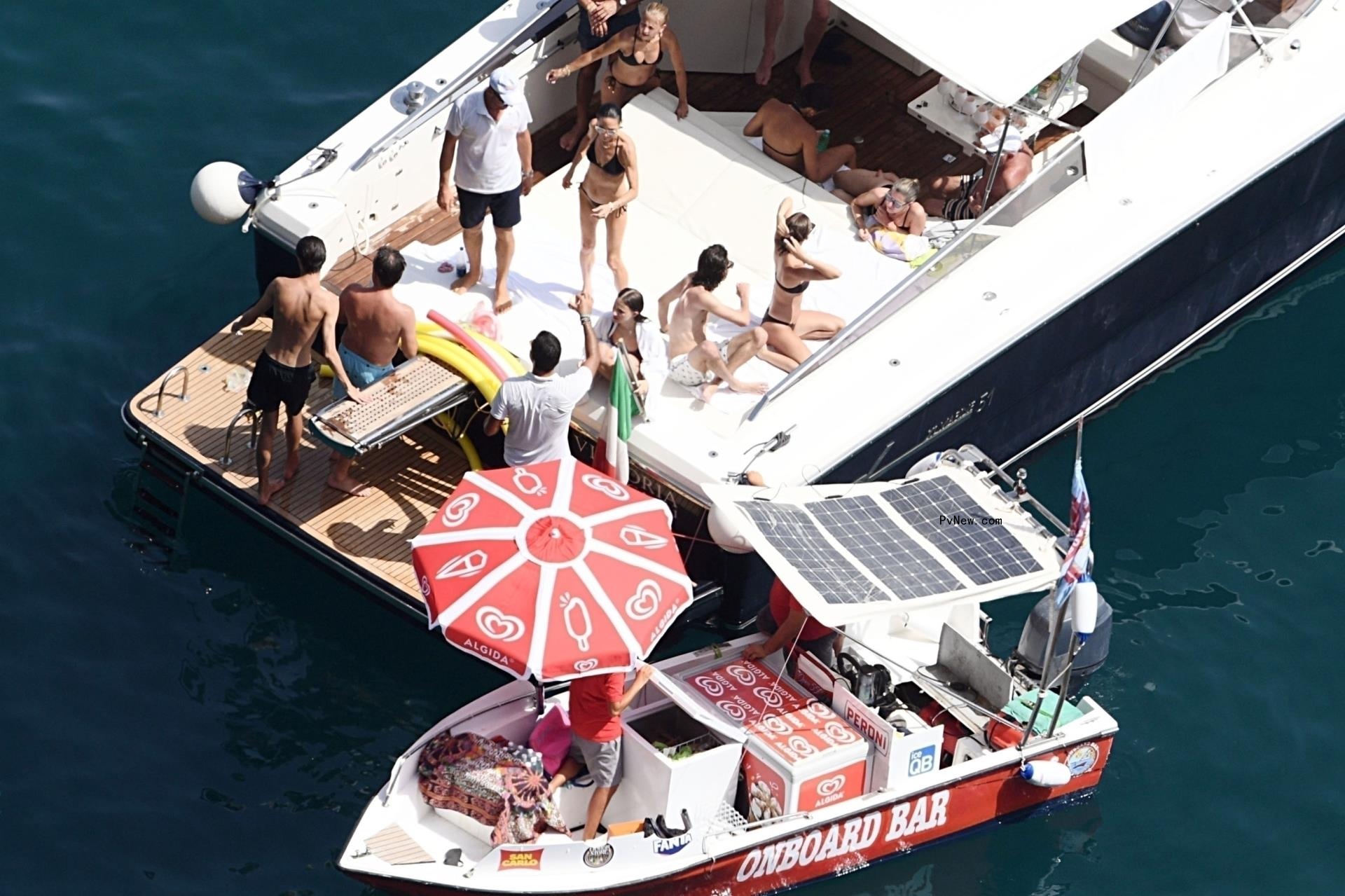 A water bar near a yacht with people.