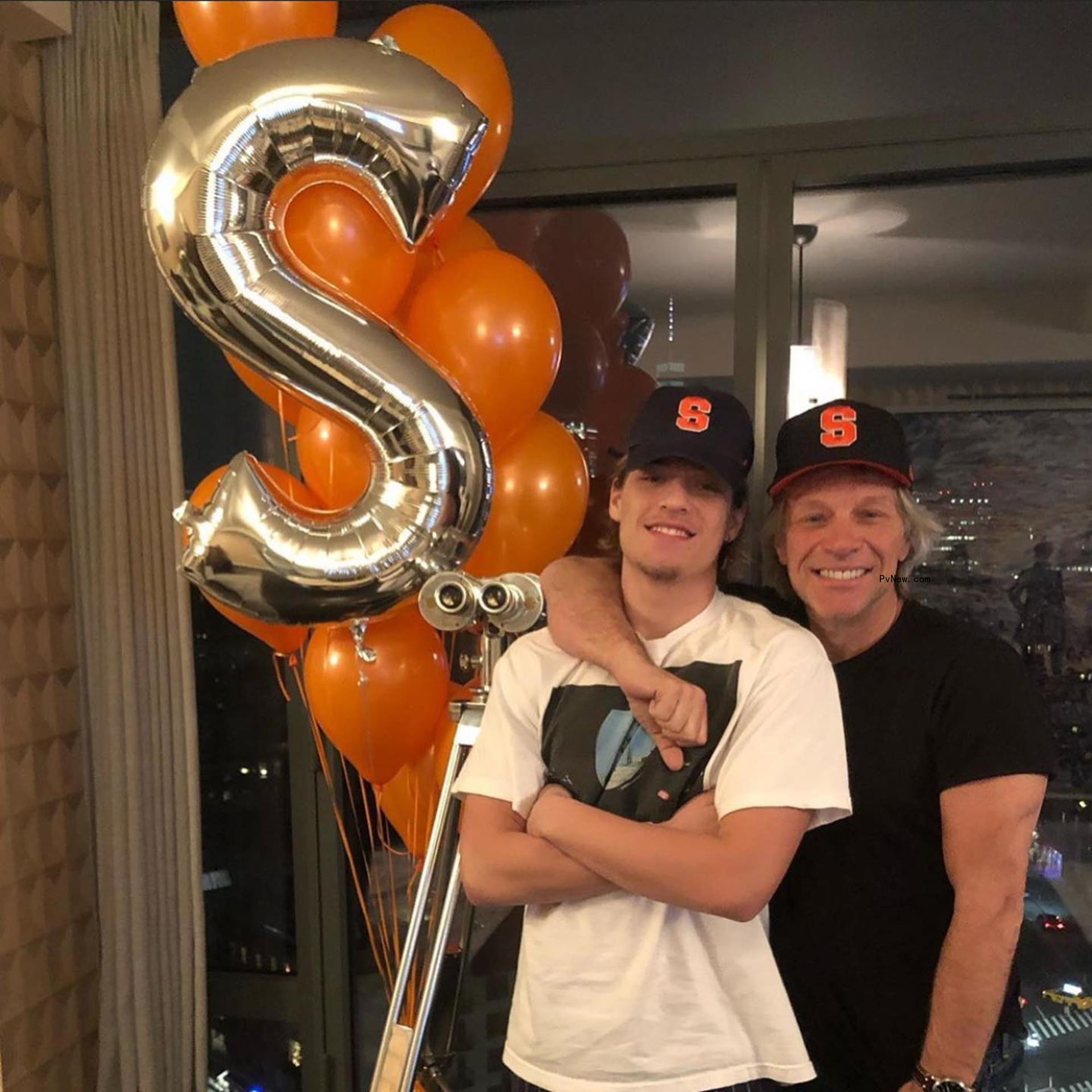 Jake Bo<i></i>ngiovi and Jon Bon Jovi posing in Syracuse University hats.