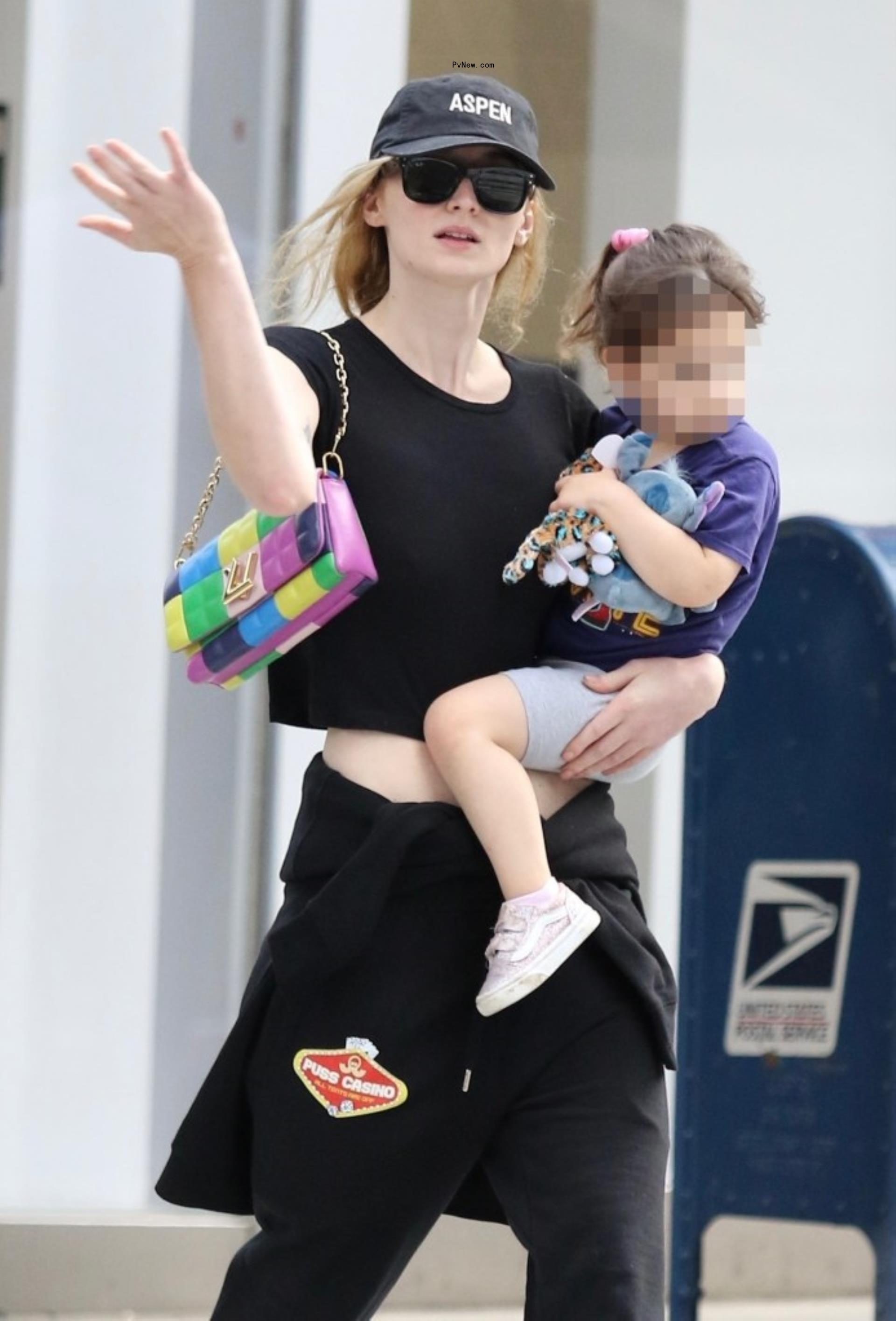 Sophie Turner wearing a Louis Vuitton purse.