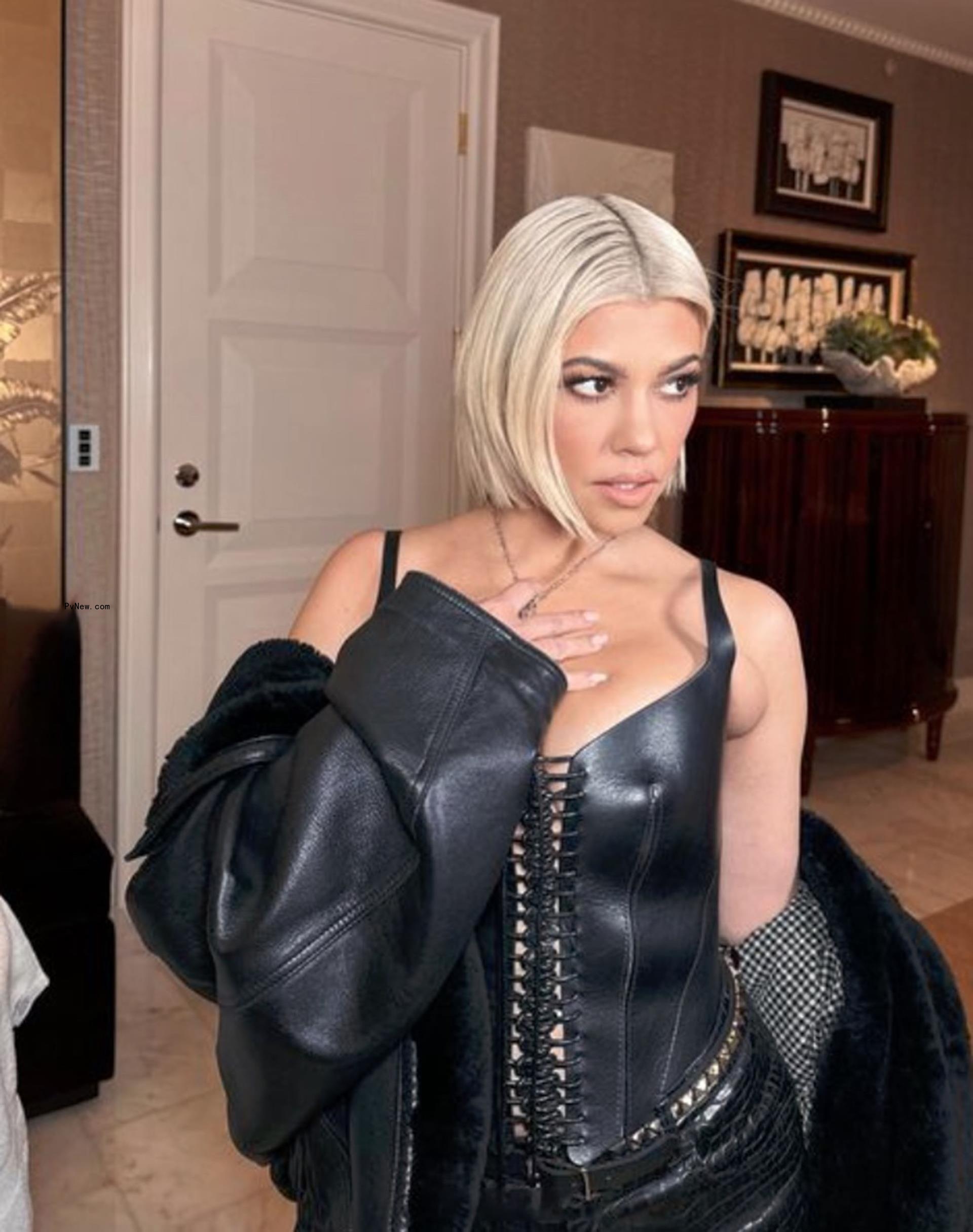 Kourtney Kardashian sporting platinum blond hair while wearing black latex