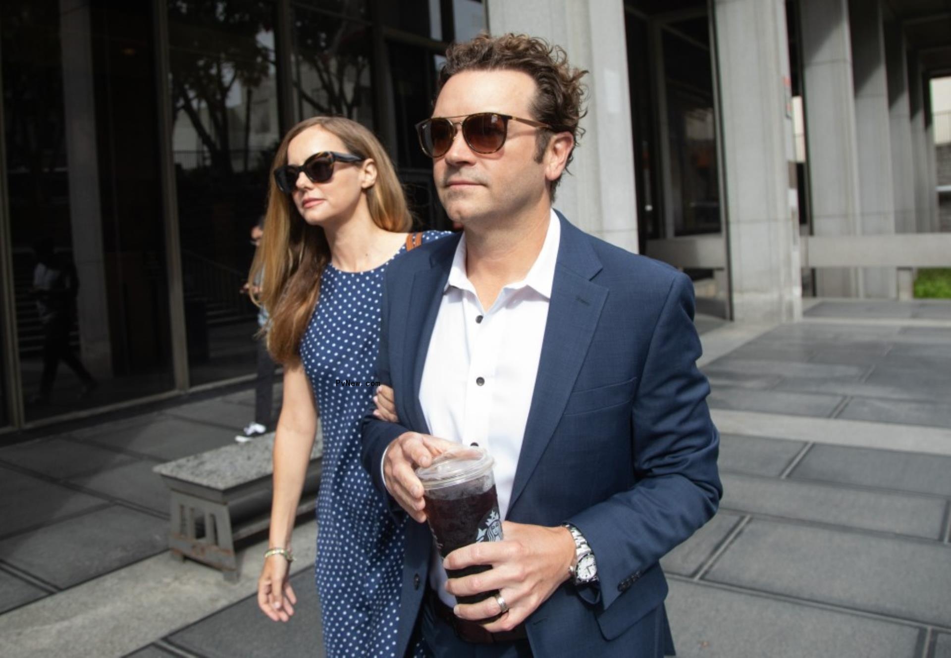 Bijou Phillips and Danny Masterson walking outside courthouse.