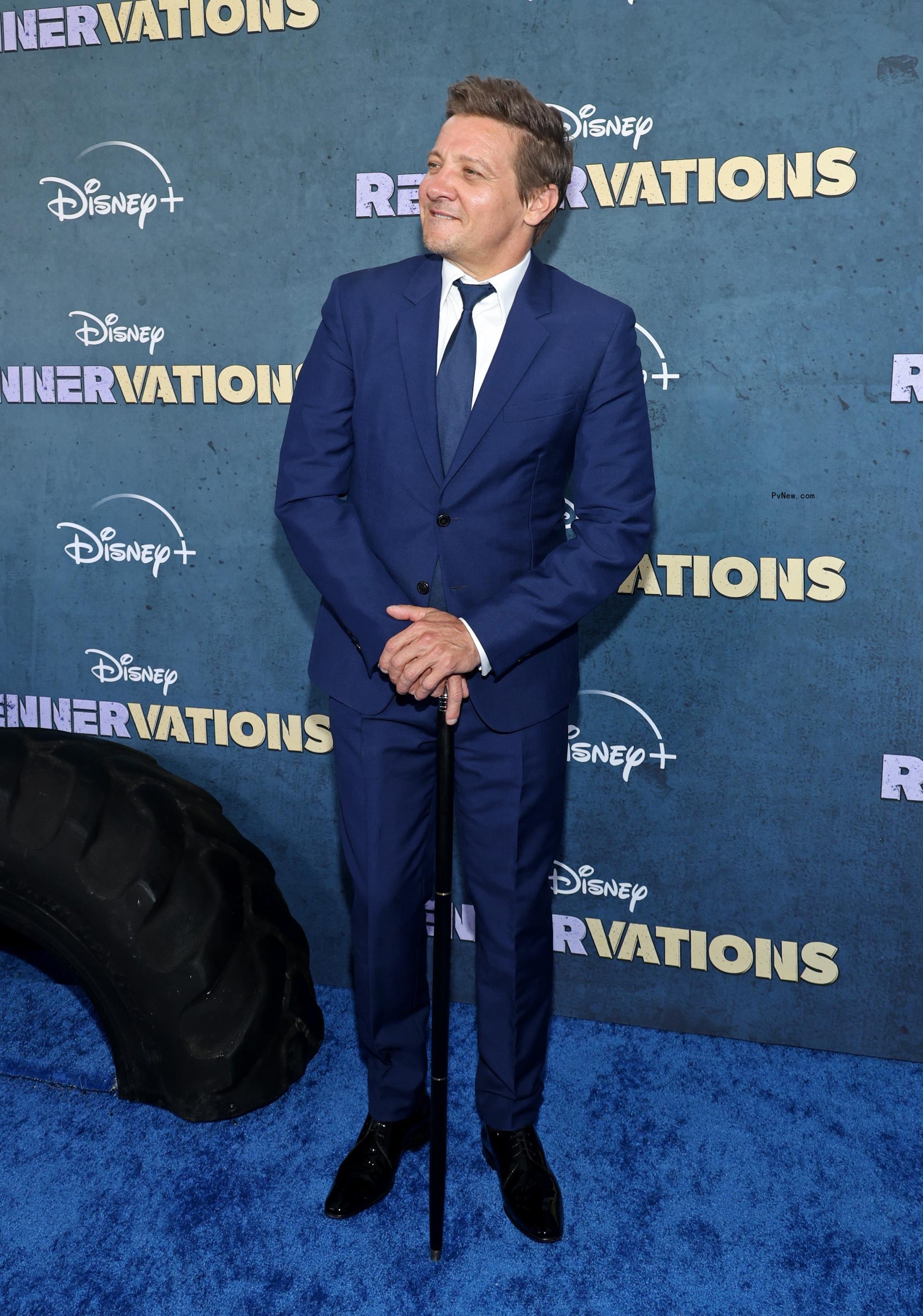 jeremy renner posing with a cane