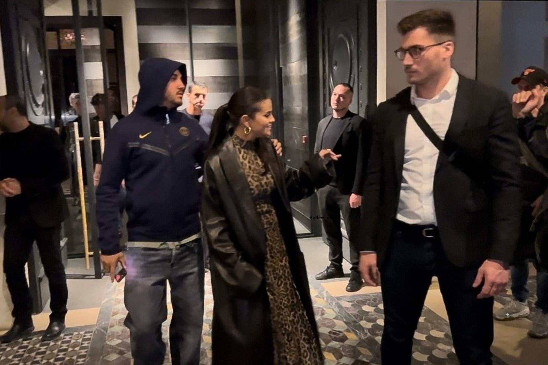 a man with his arms around selena gomez who is waving to fans