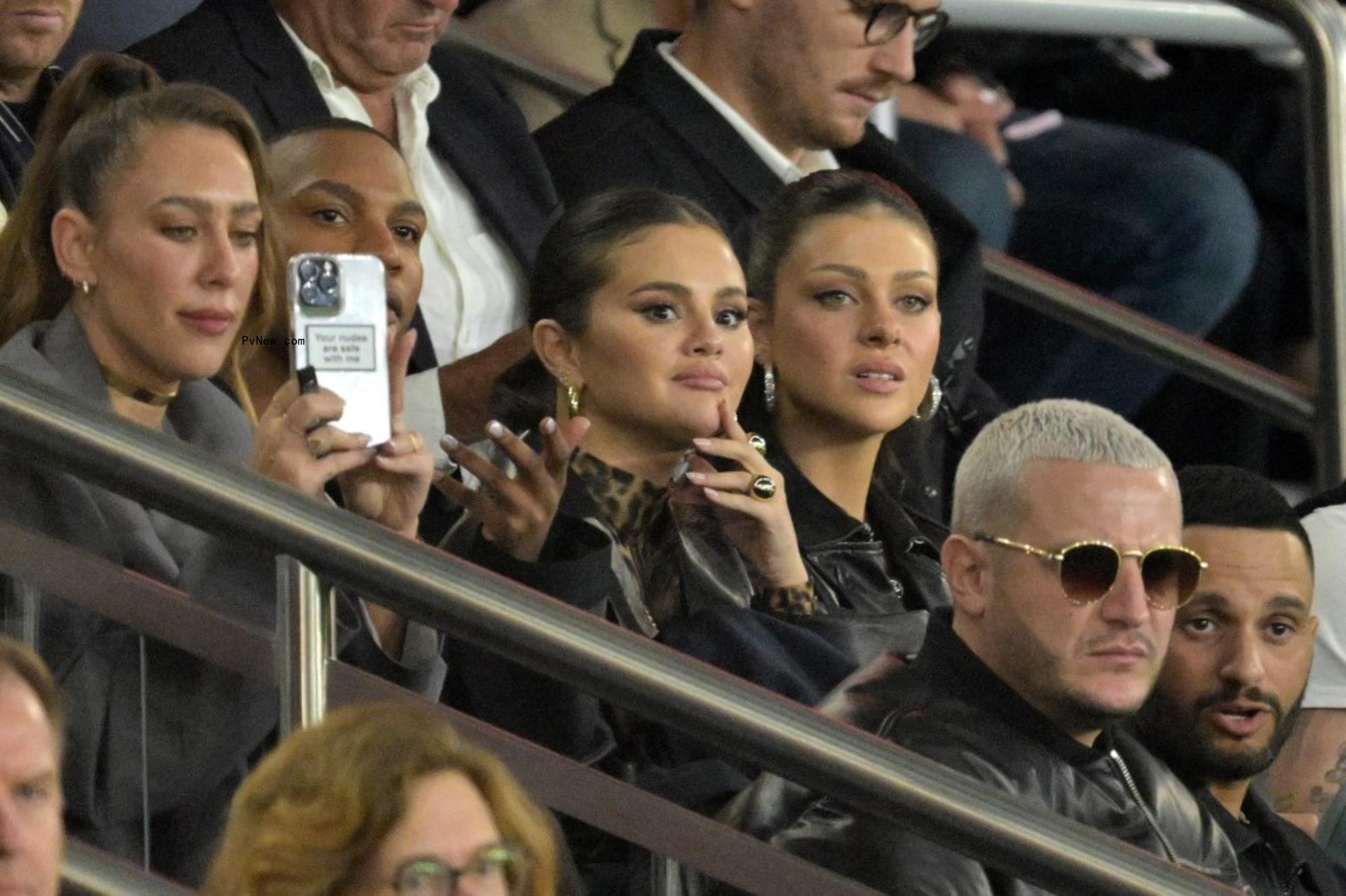 selena gomez and nicola pelts sitting in soccer stands