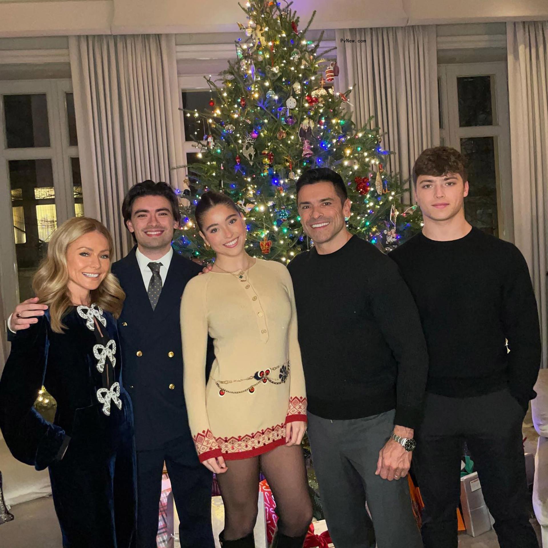 Mark Consuelos, Kelly Ripa and their three kids around the Christmas tree.