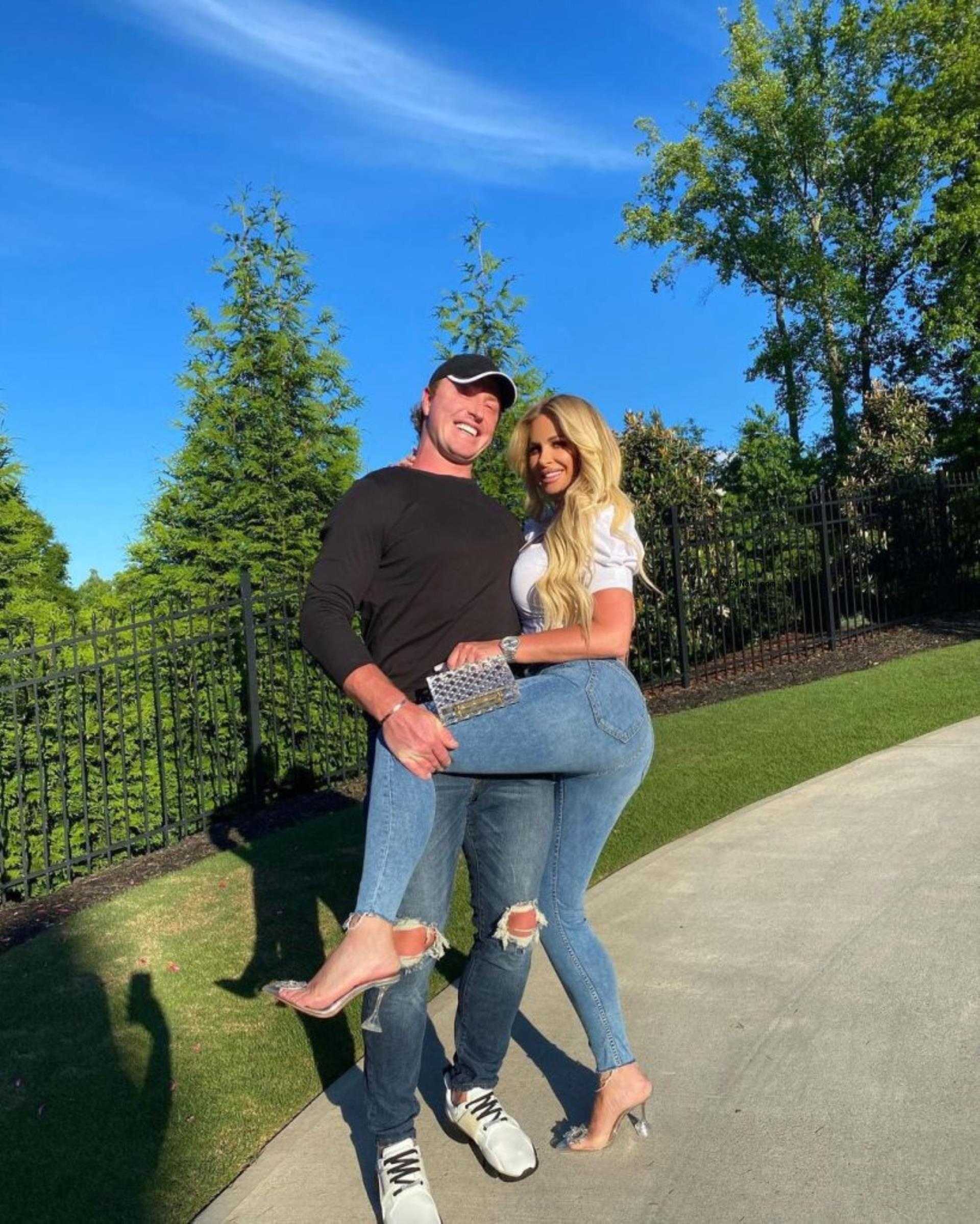 kroy biermann holding up kim zolciak's leg in a pose