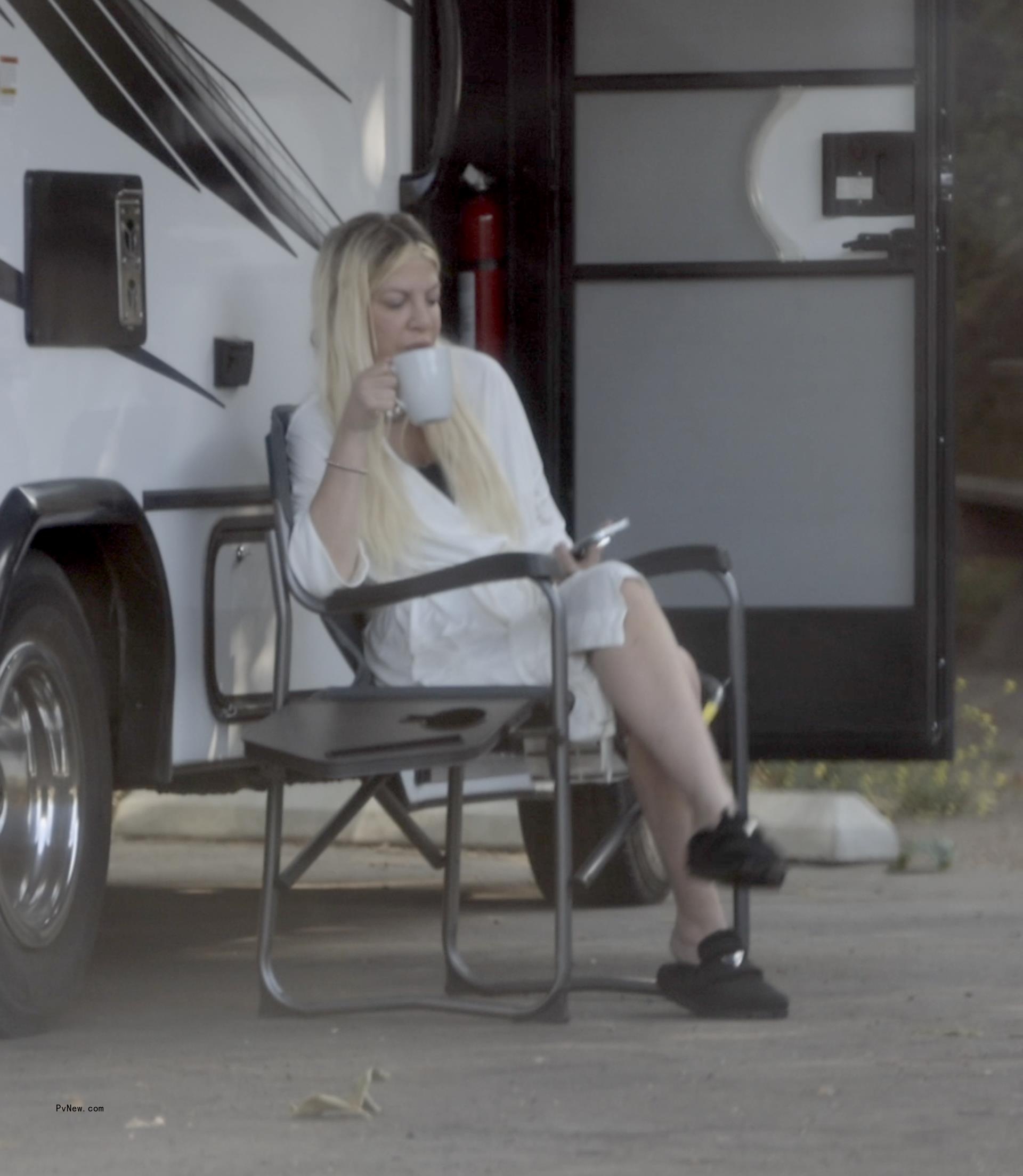 Tori Spelling sitting outside an RV