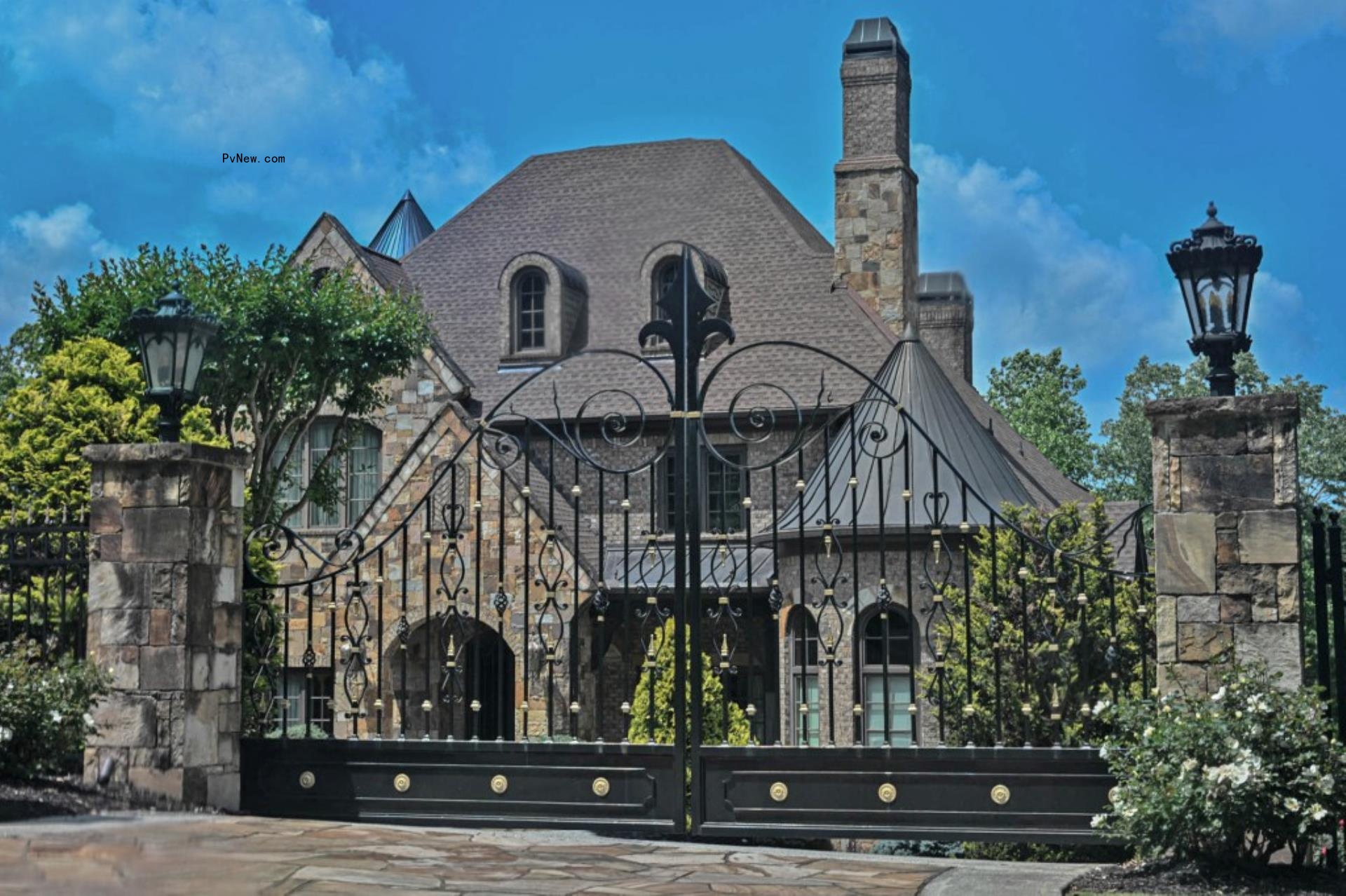 exterior of a stone mansion with a wrought iron gate