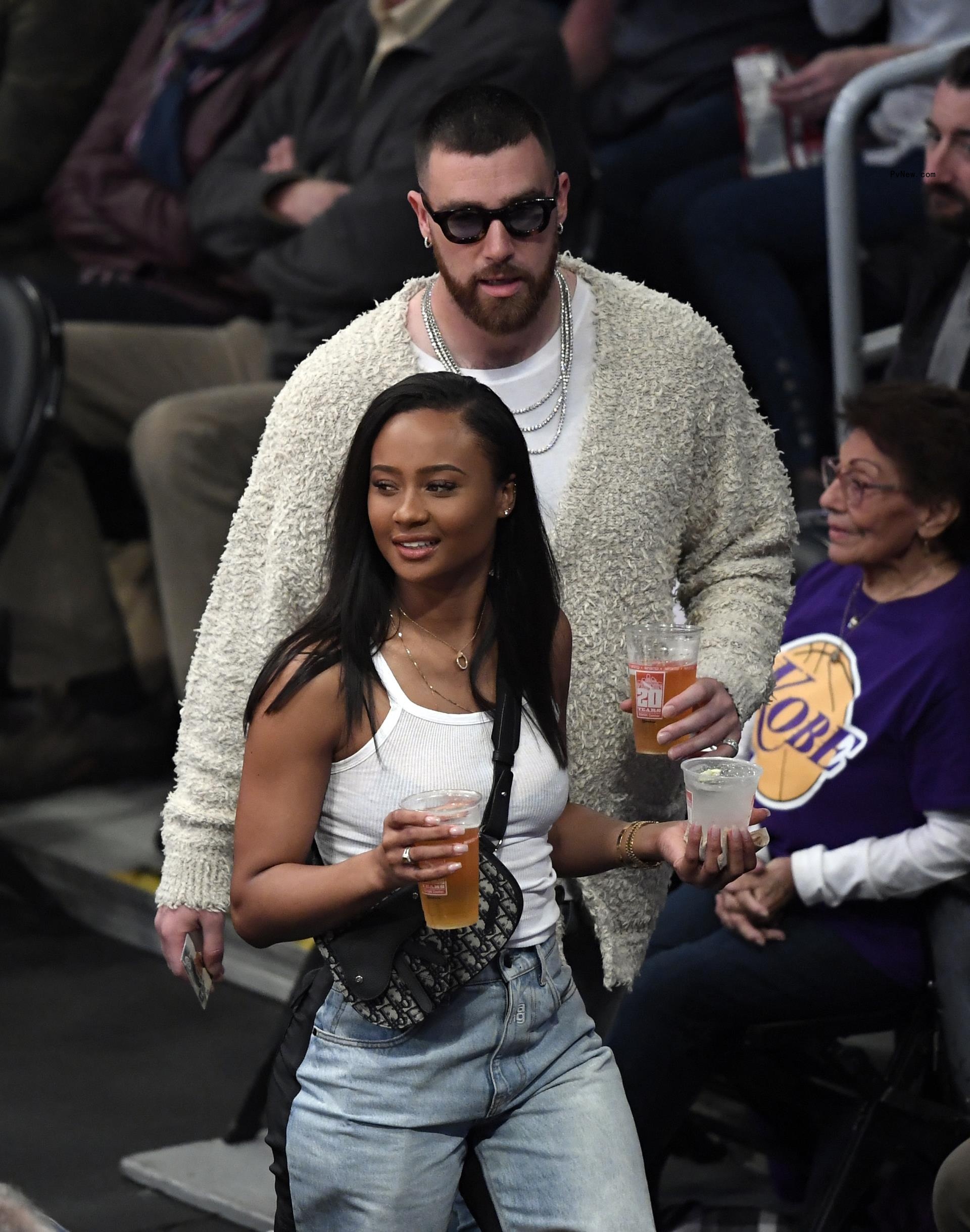 Travis Kelce and Kayla Nicole walking at a basketball game