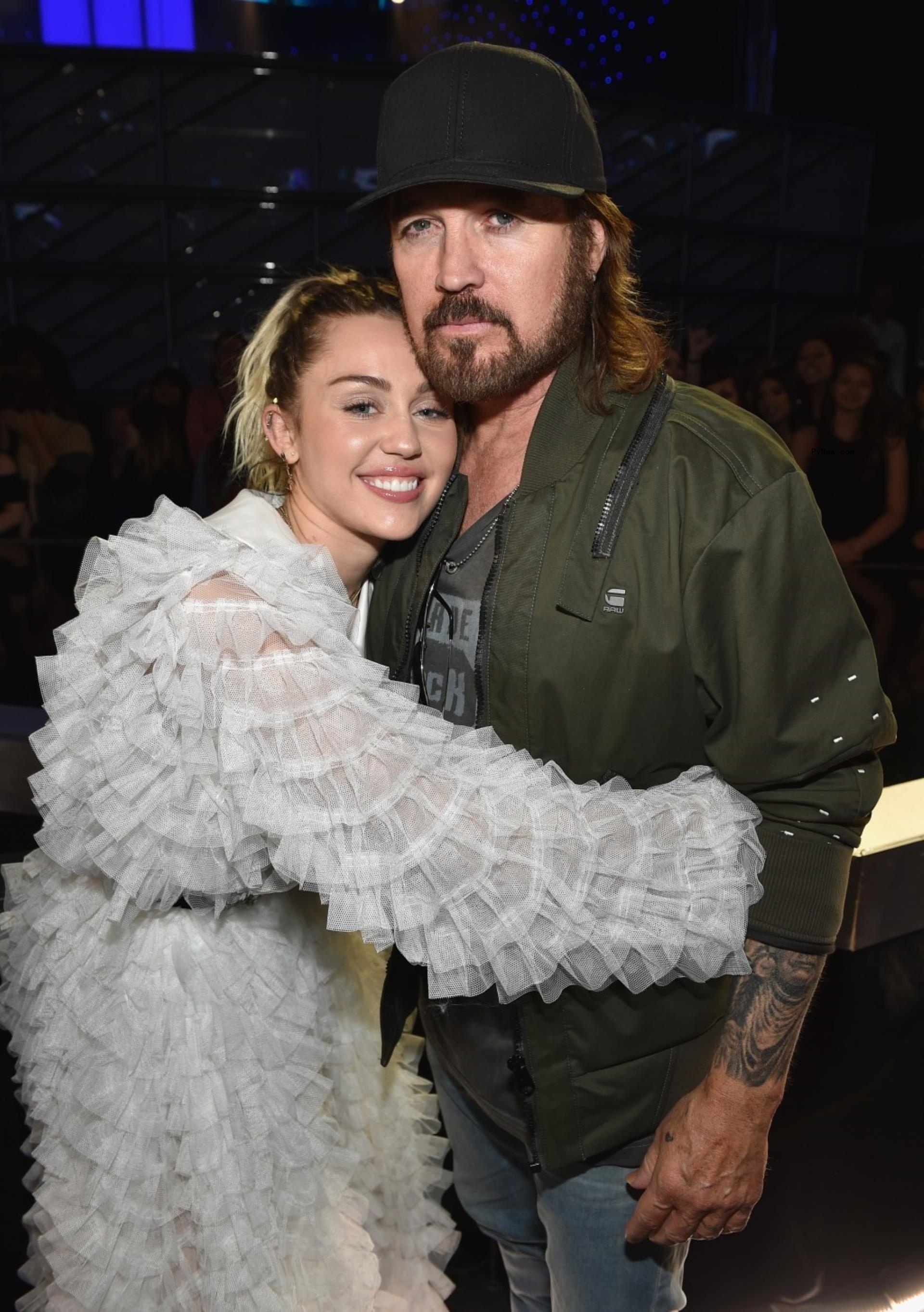 Miley and Billy Ray Cyrus hugging.