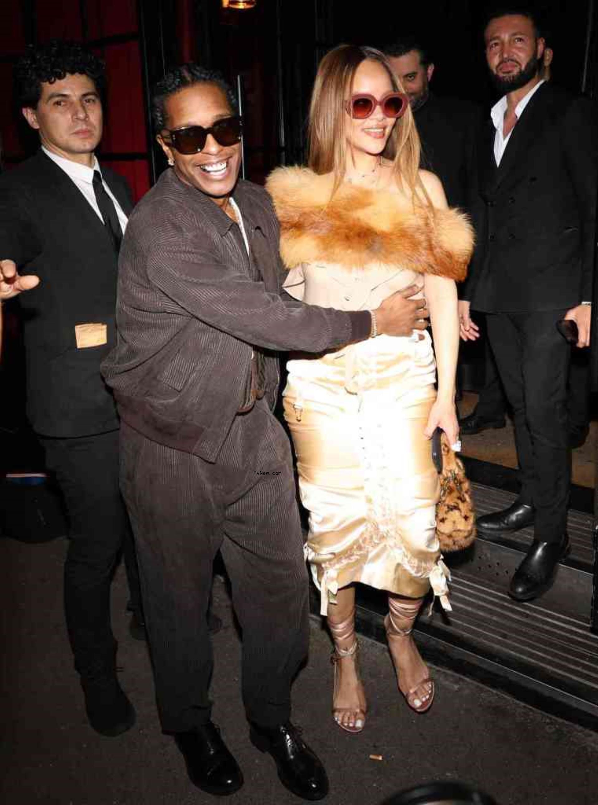 A$AP Rocky holds Rihanna as the two smile.