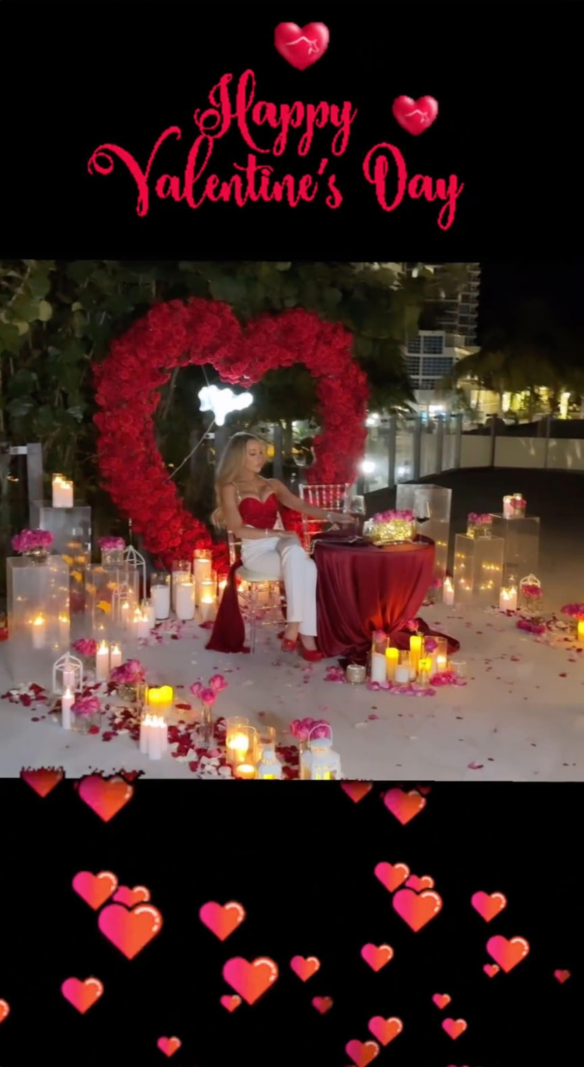 lisa hochstein sitting at a small table surrounded by candles, roses and a heart-shaped rose wreath