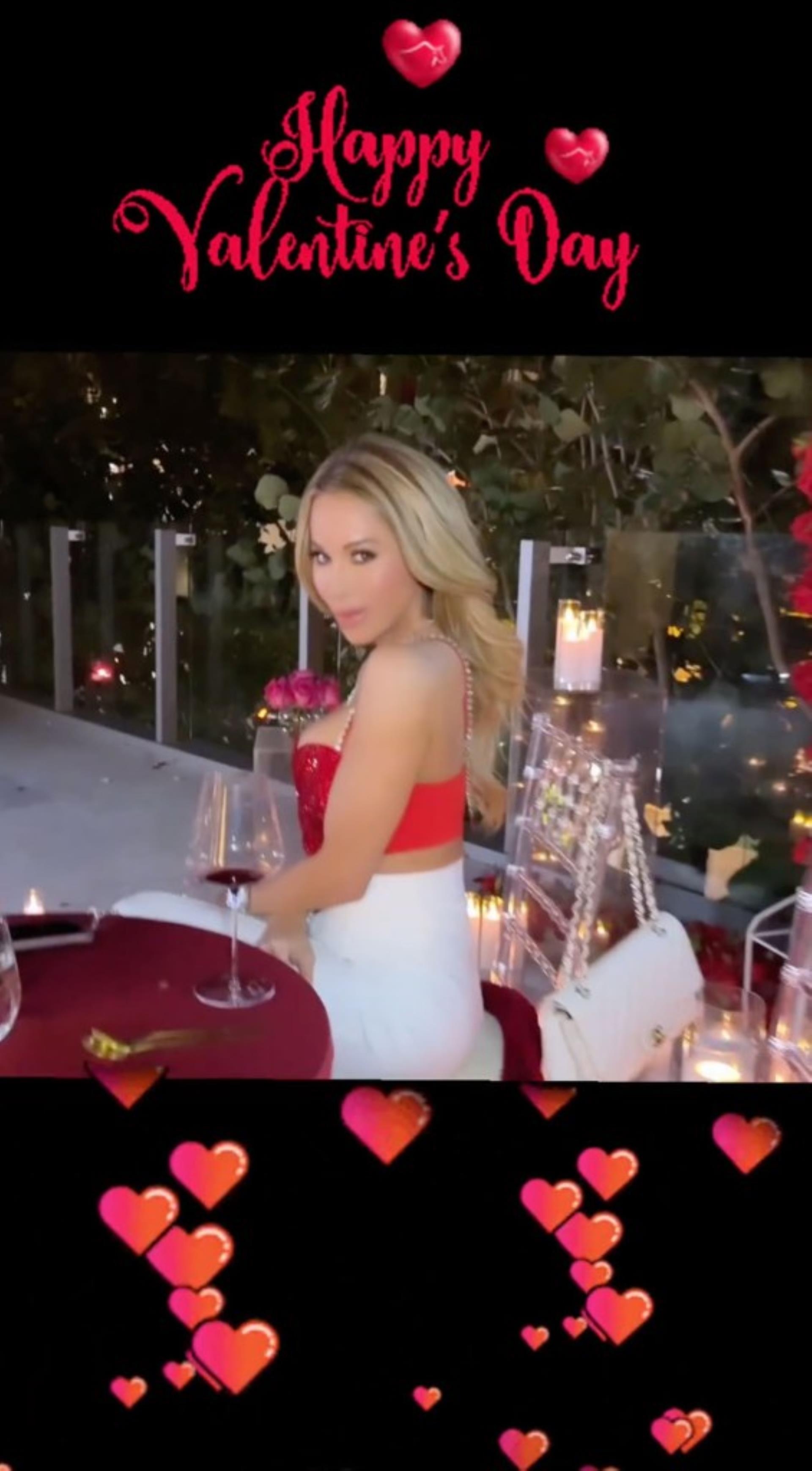 lisa hochstein sitting at a red tablecloth-covered table with a glass of wine