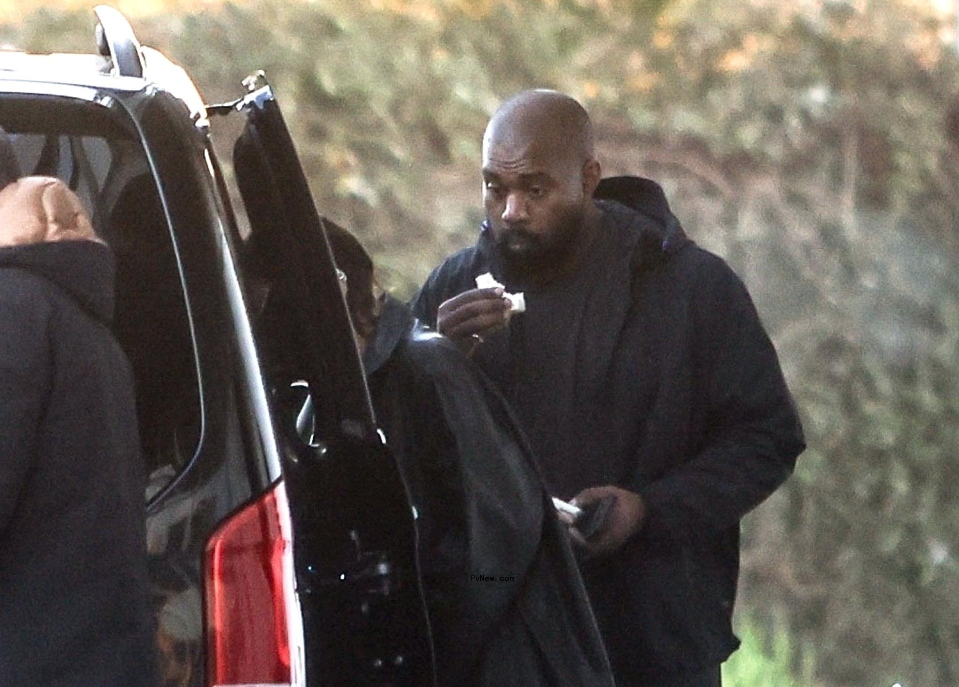Kanye West getting into a car with Bianca Censori.