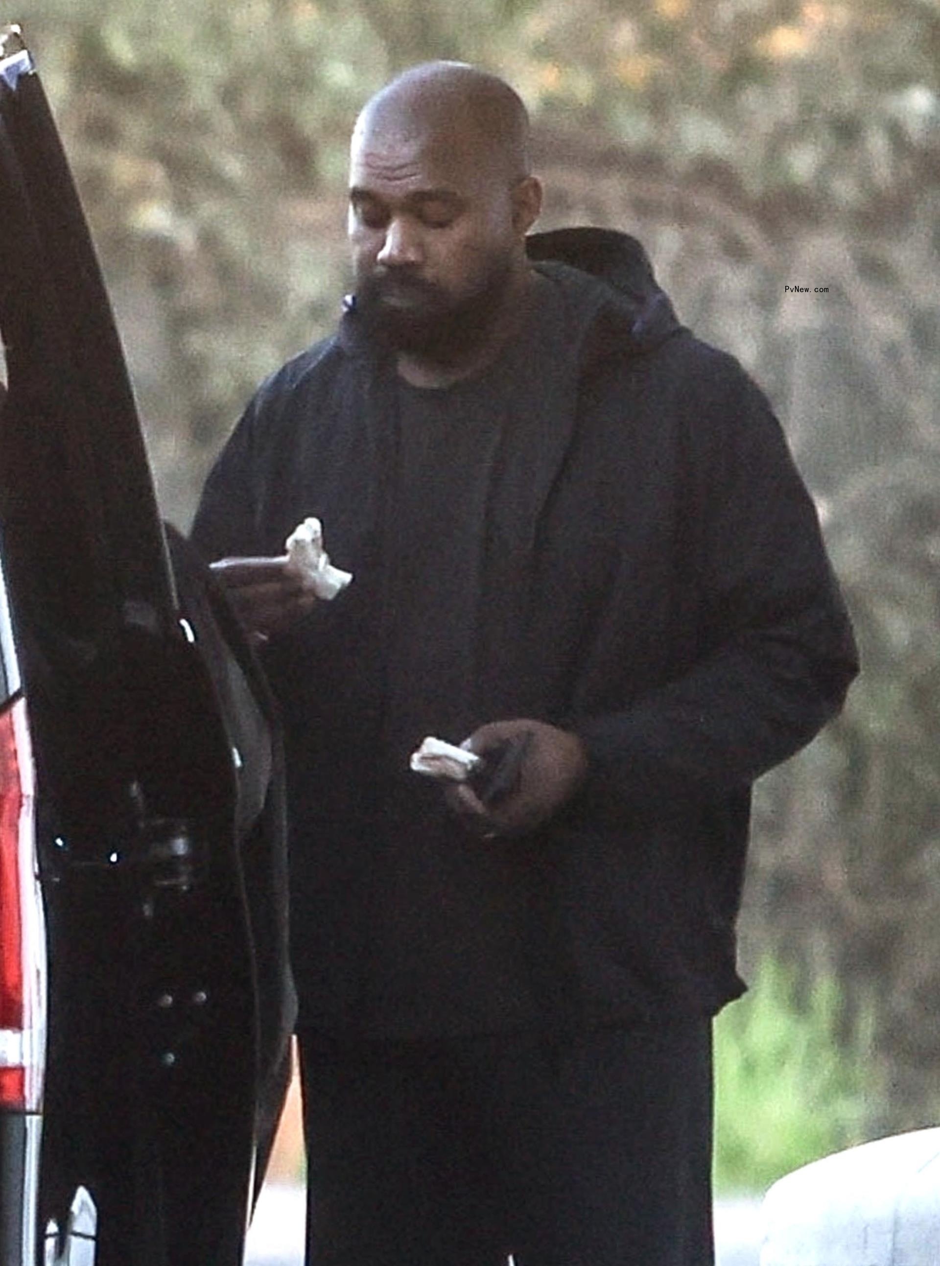 Kanye West eating a sandwich.