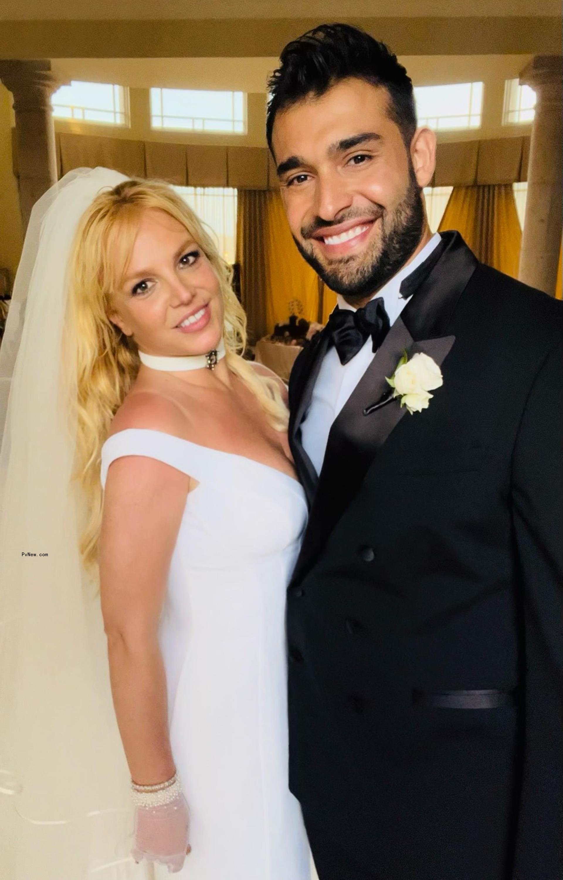 Britney Spears in her white wedding gown and veil with her husband Sam Ashgari, wearing a black tux on their wedding day.