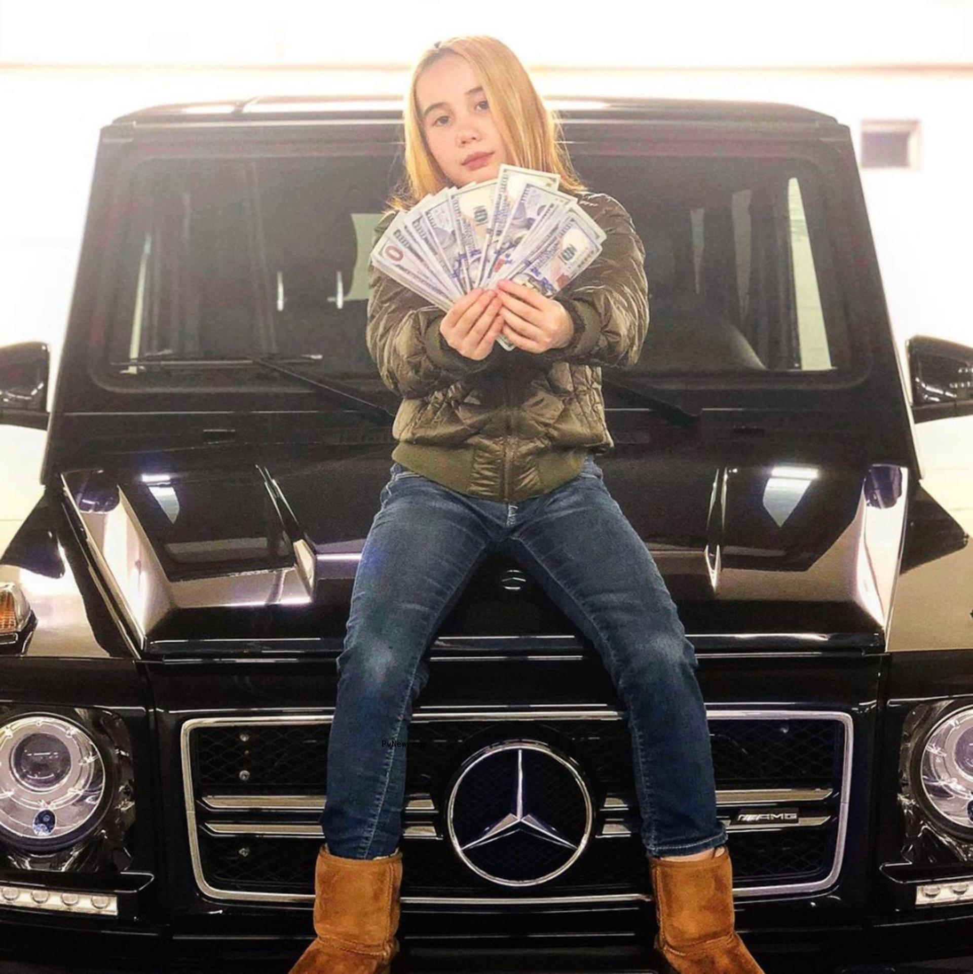 Lil Tay on a car holding money.