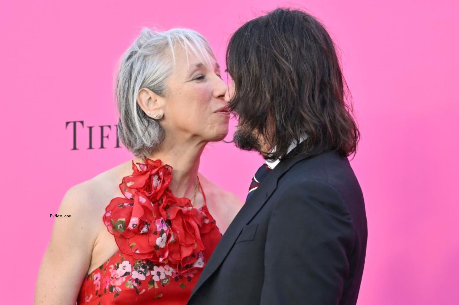 Alexandra Grant and Keanu Reeves kissing.