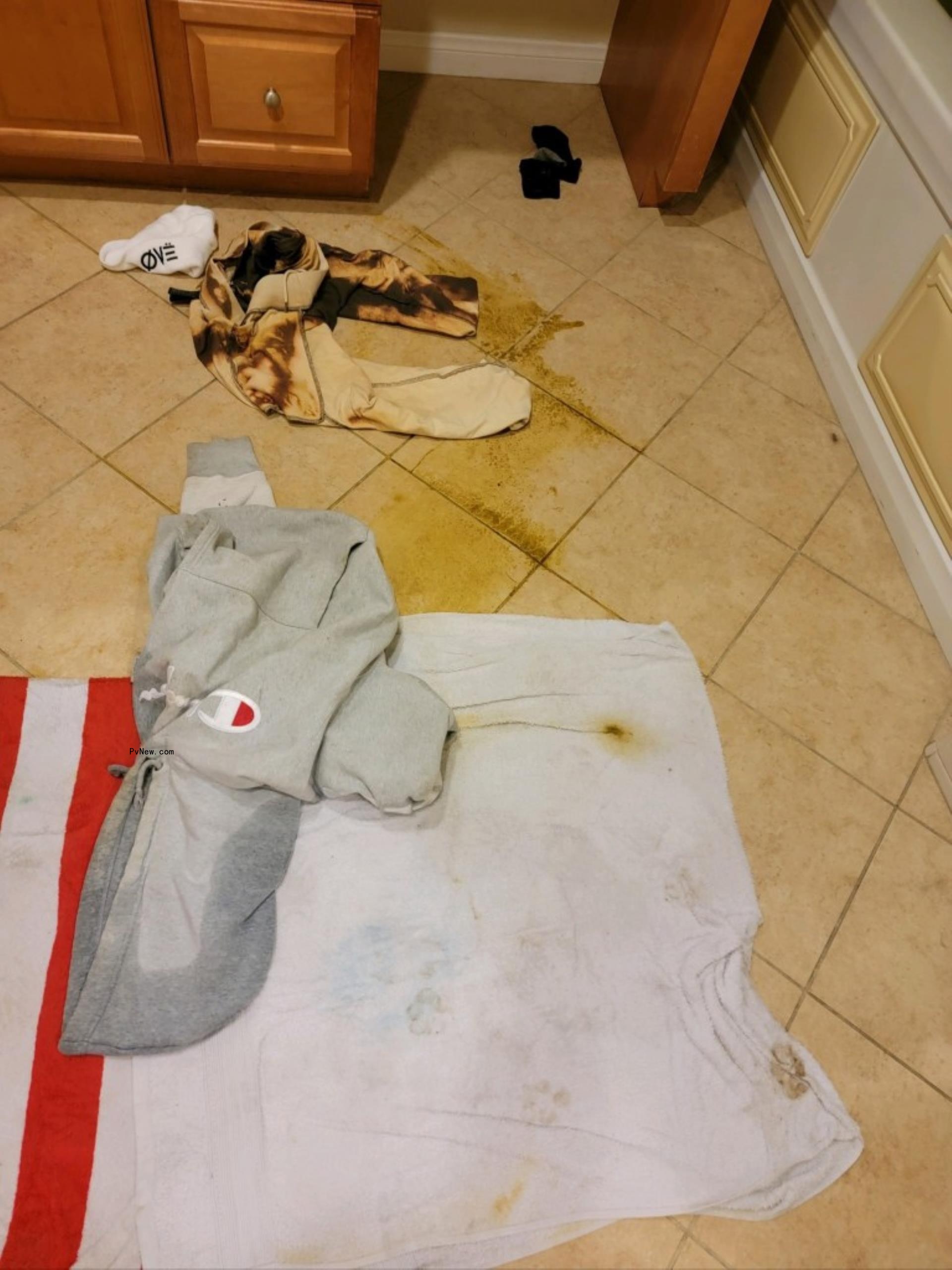 Aaron Carter's bathroom with dirty clothes and stains on the floor.
