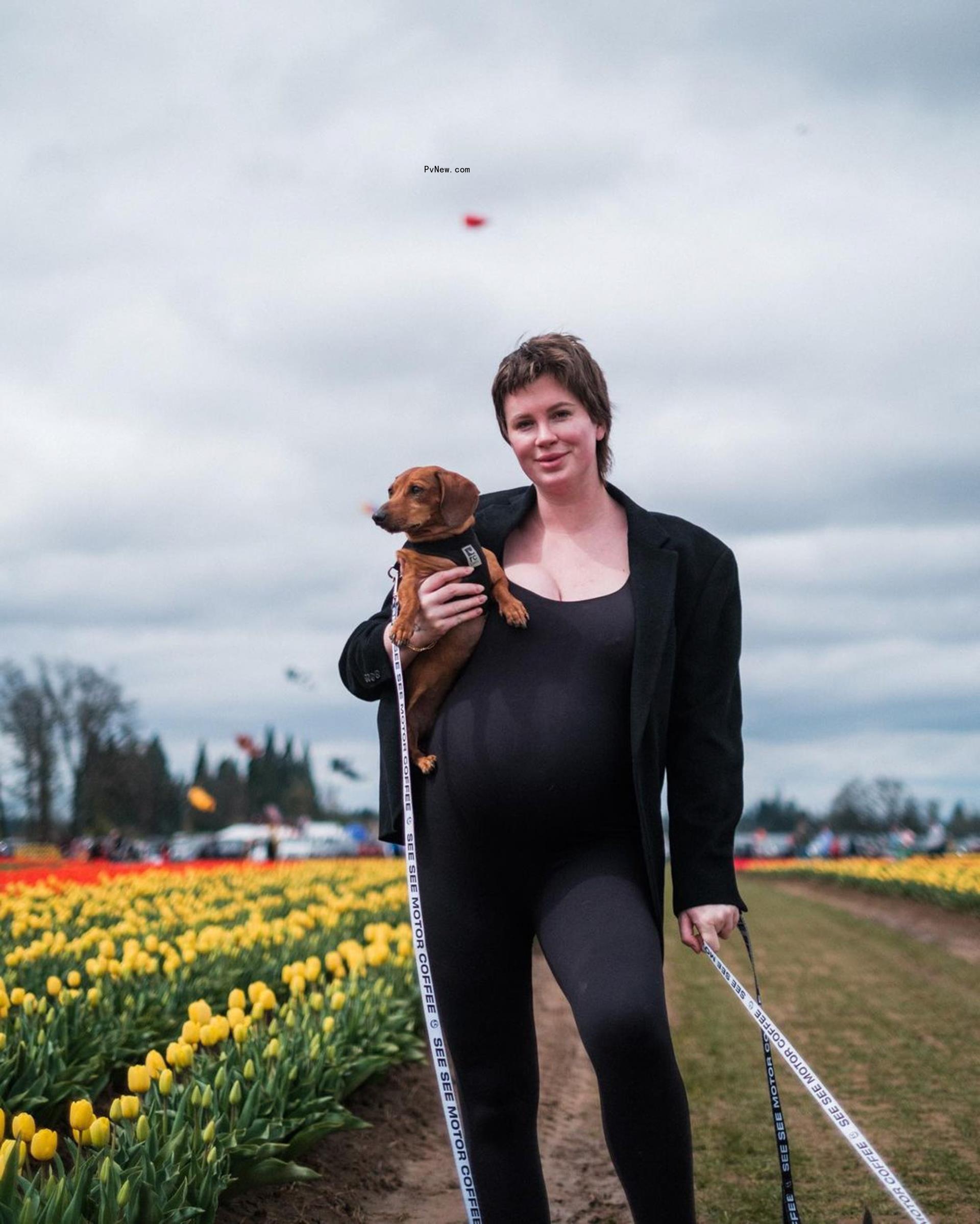 Ireland Baldwin smiles with dog in arms