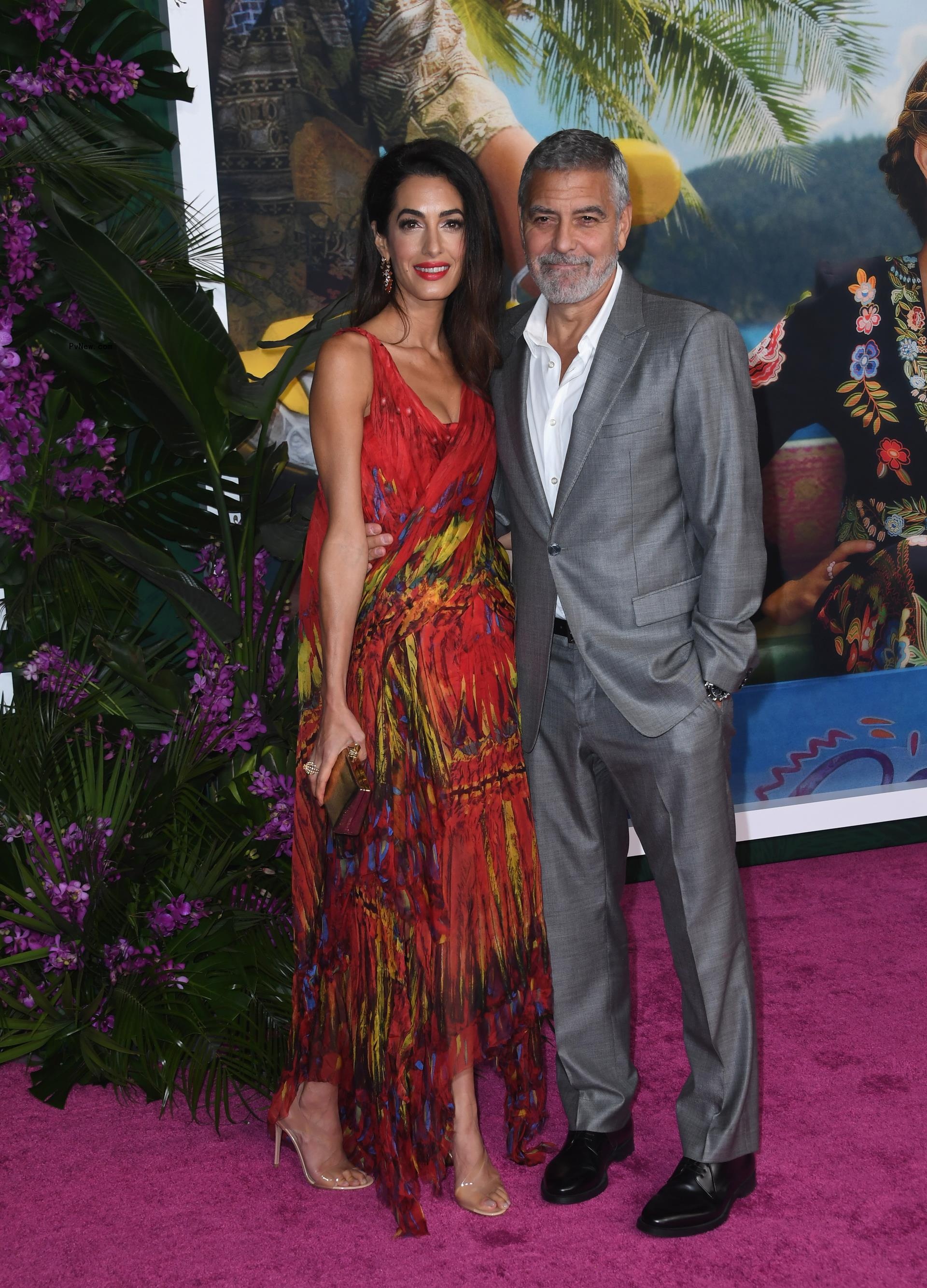 George and Amal Cloo<i></i>ney on a red carpet.
