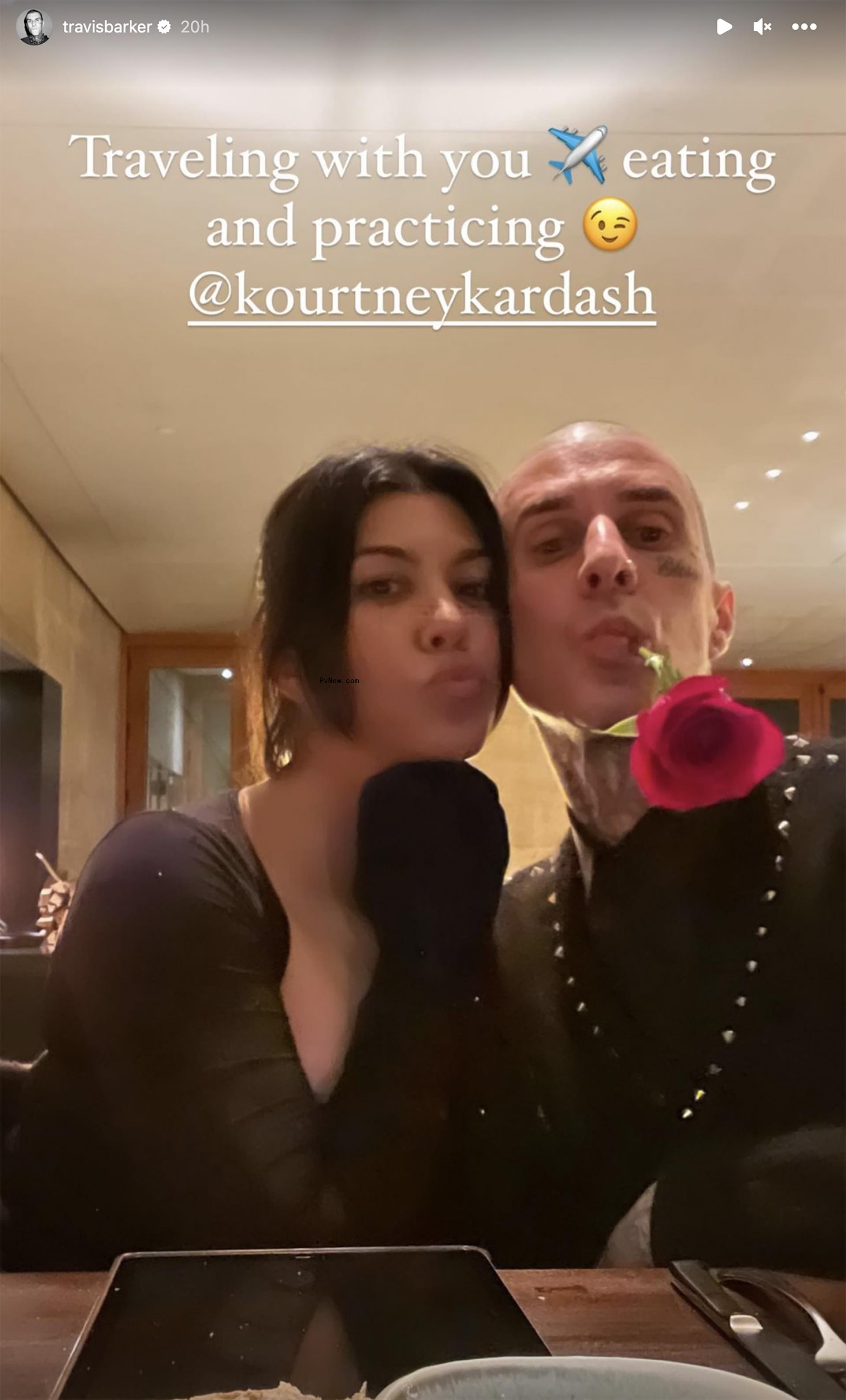 Kourtney Kardashian and Travis Barker pose in a restaurnt