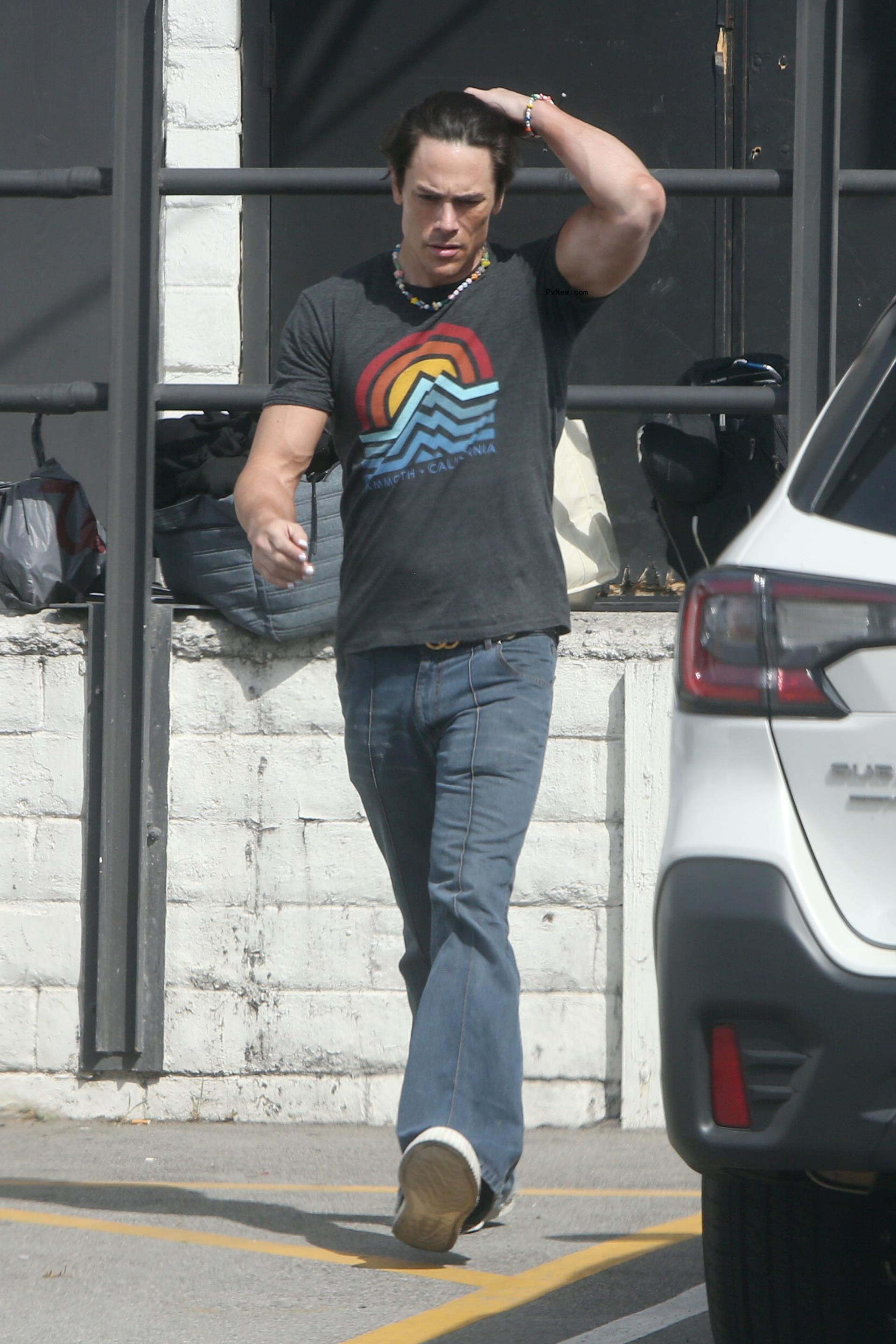 Tom Sandoval walks in graphic tee and jeans