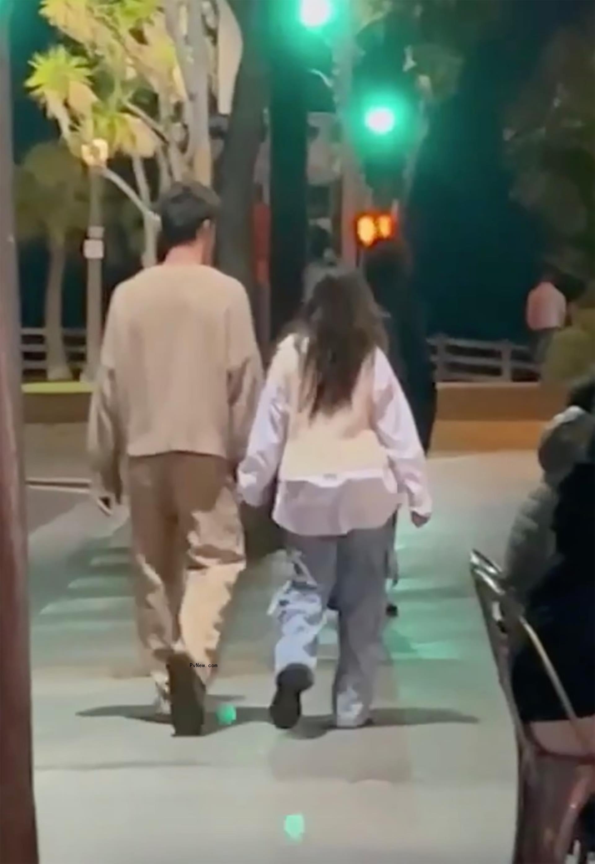 Shawn Mendes and Camila Cabello holding hands while walking together.