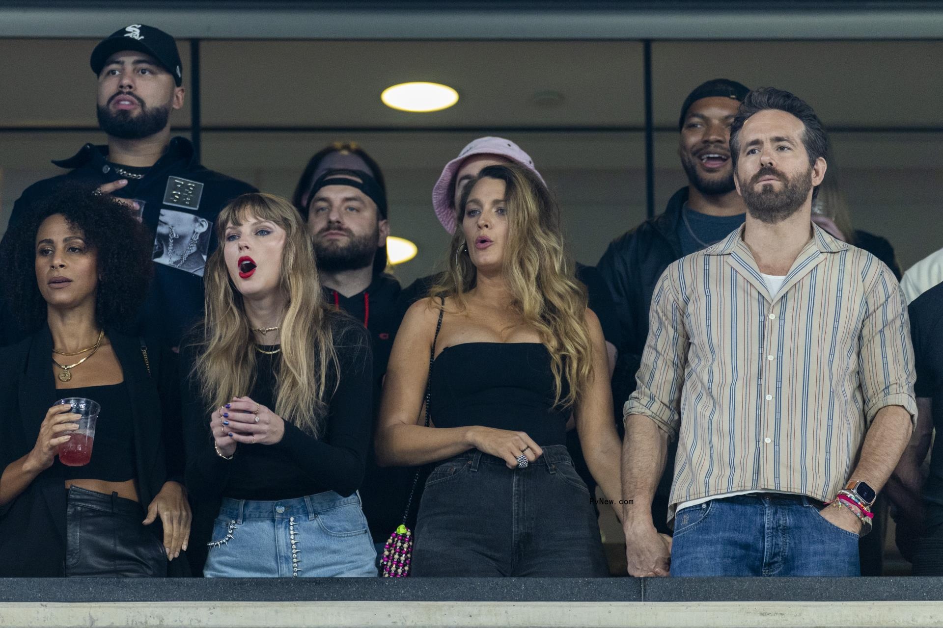 Taylor Swift reacts alo<i></i>ngside actor Blake Lively as she holds her husband Ryan Reynolds hand in the first half at MetLife Stadium