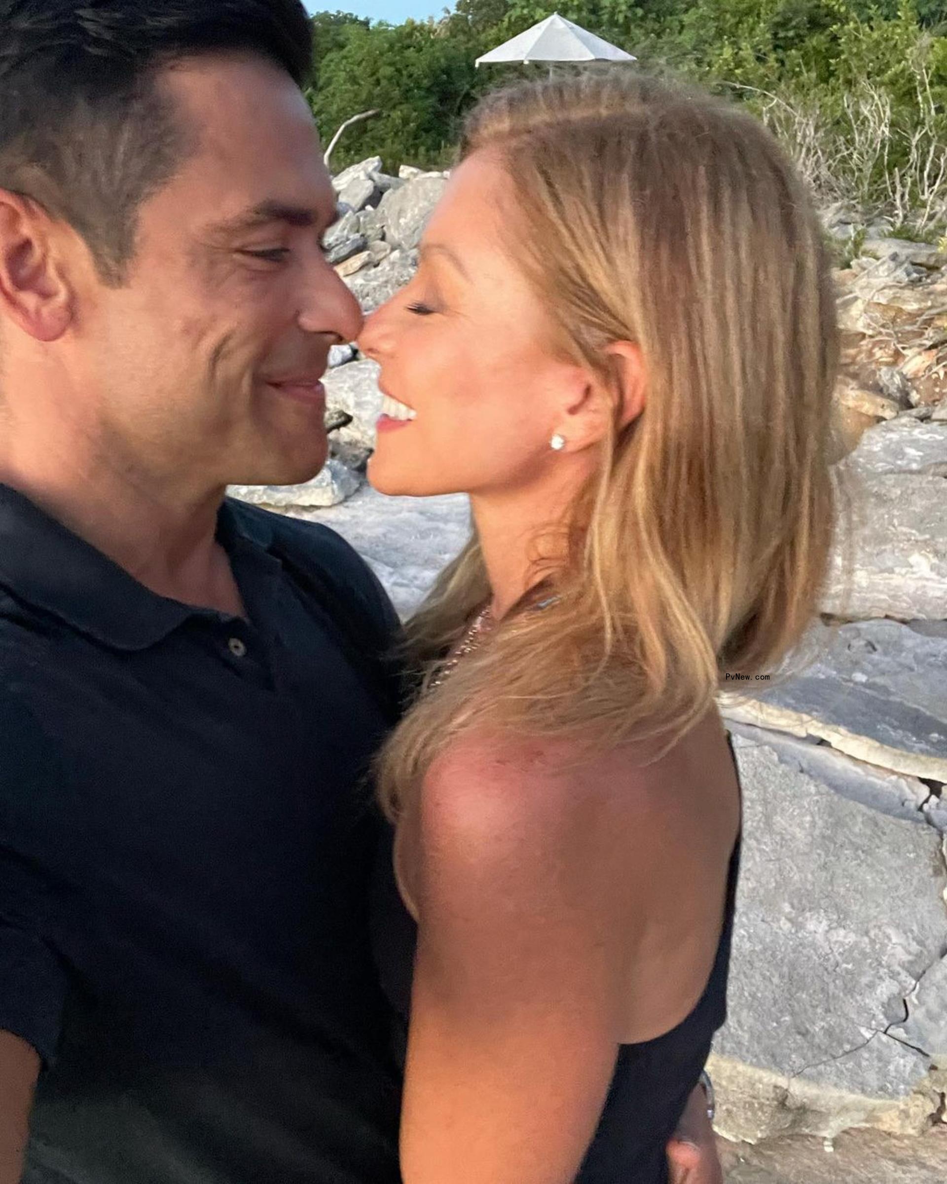 Kelly Ripa and Mark Co<i></i>nsuelos hugging while taking a selfie.