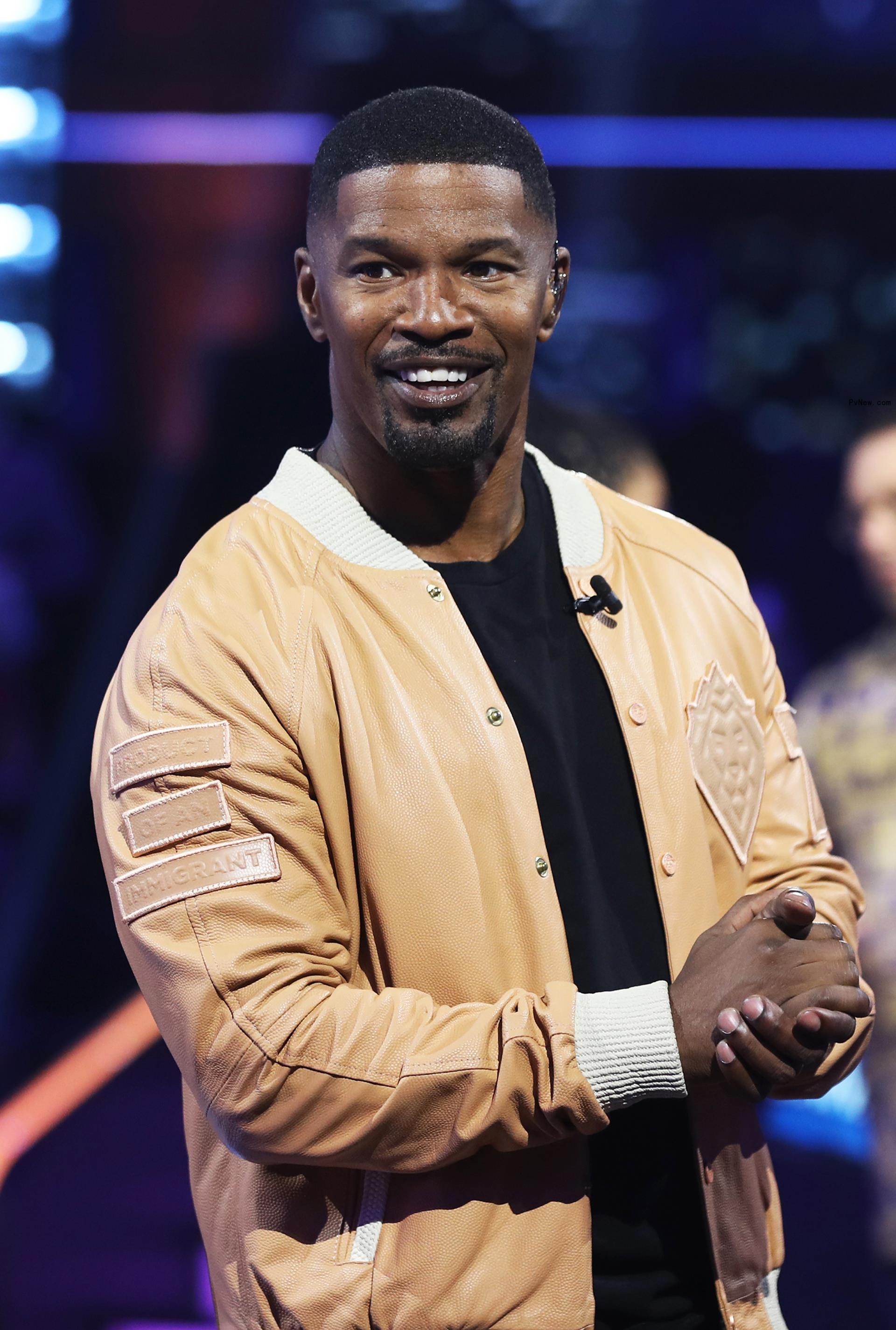 Jamie Foxx smiles in leather jacket