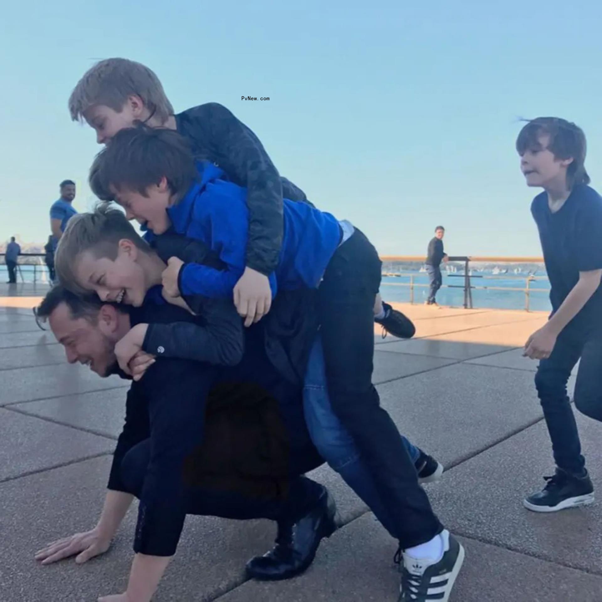 elon musk with three of his sons piling o<i></i>nto his back