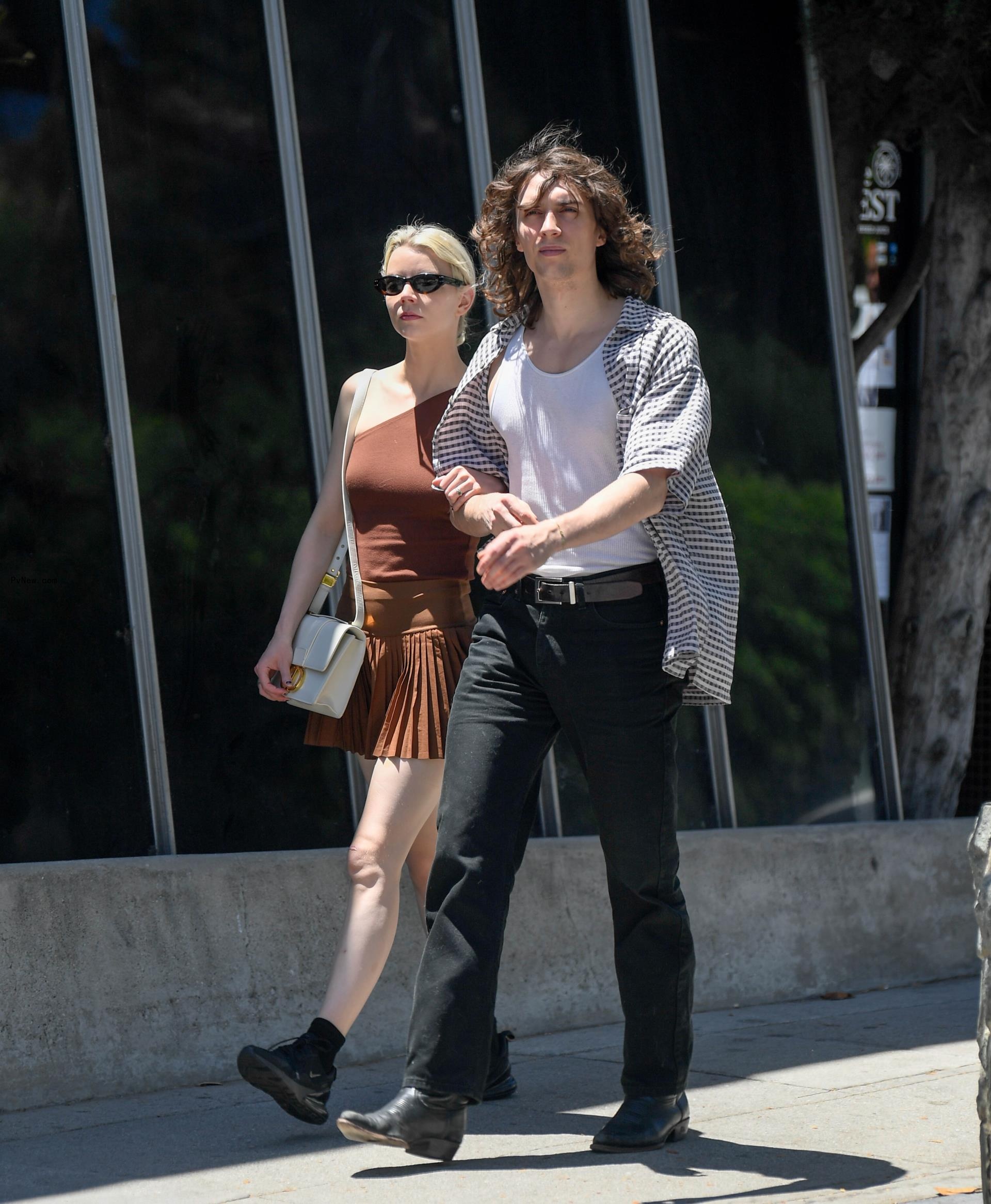 Anya Taylor-Joy and Malcolm McRae walking outside.
