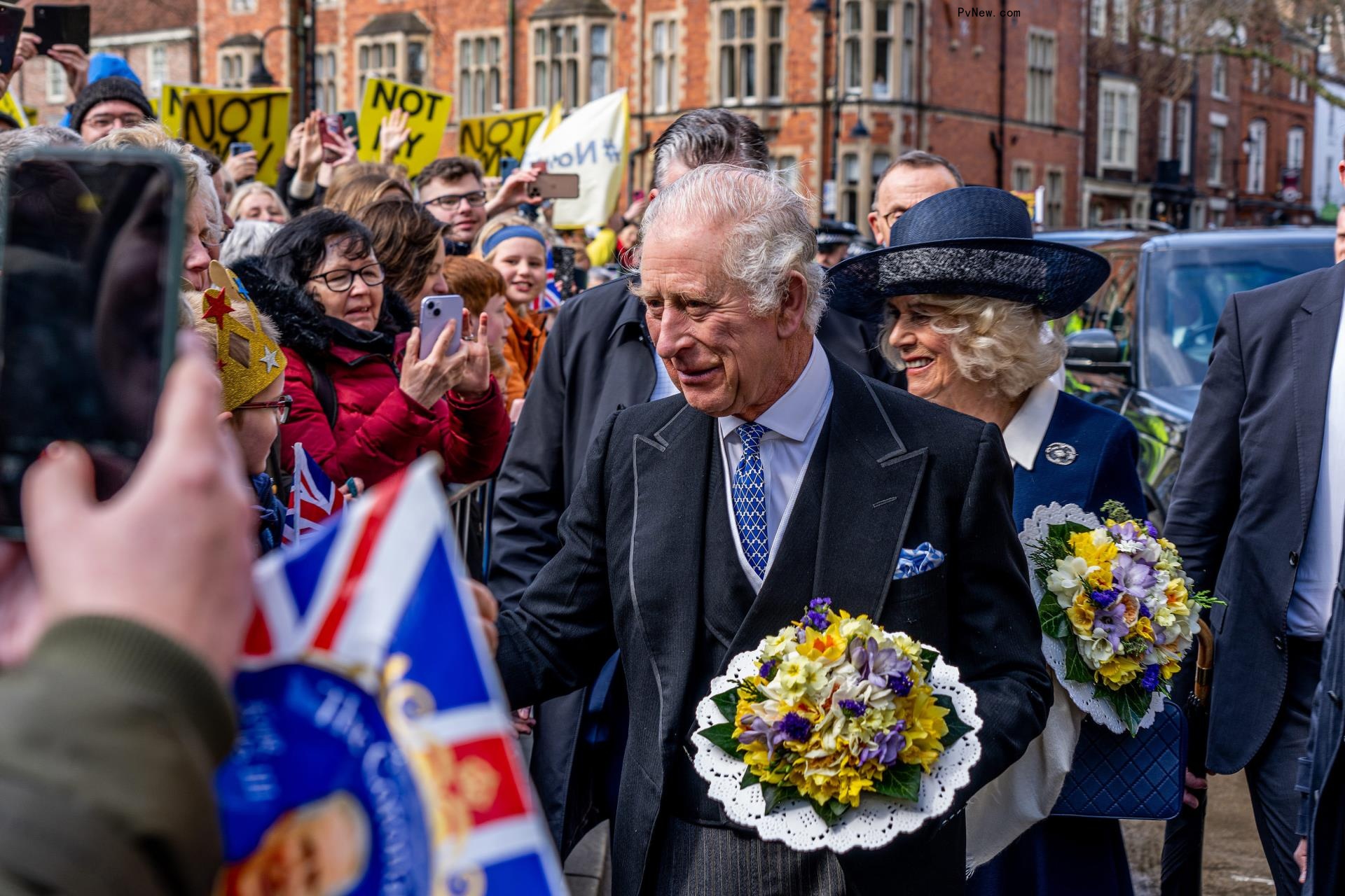 King Charles III and Queen Camilla greeting people.