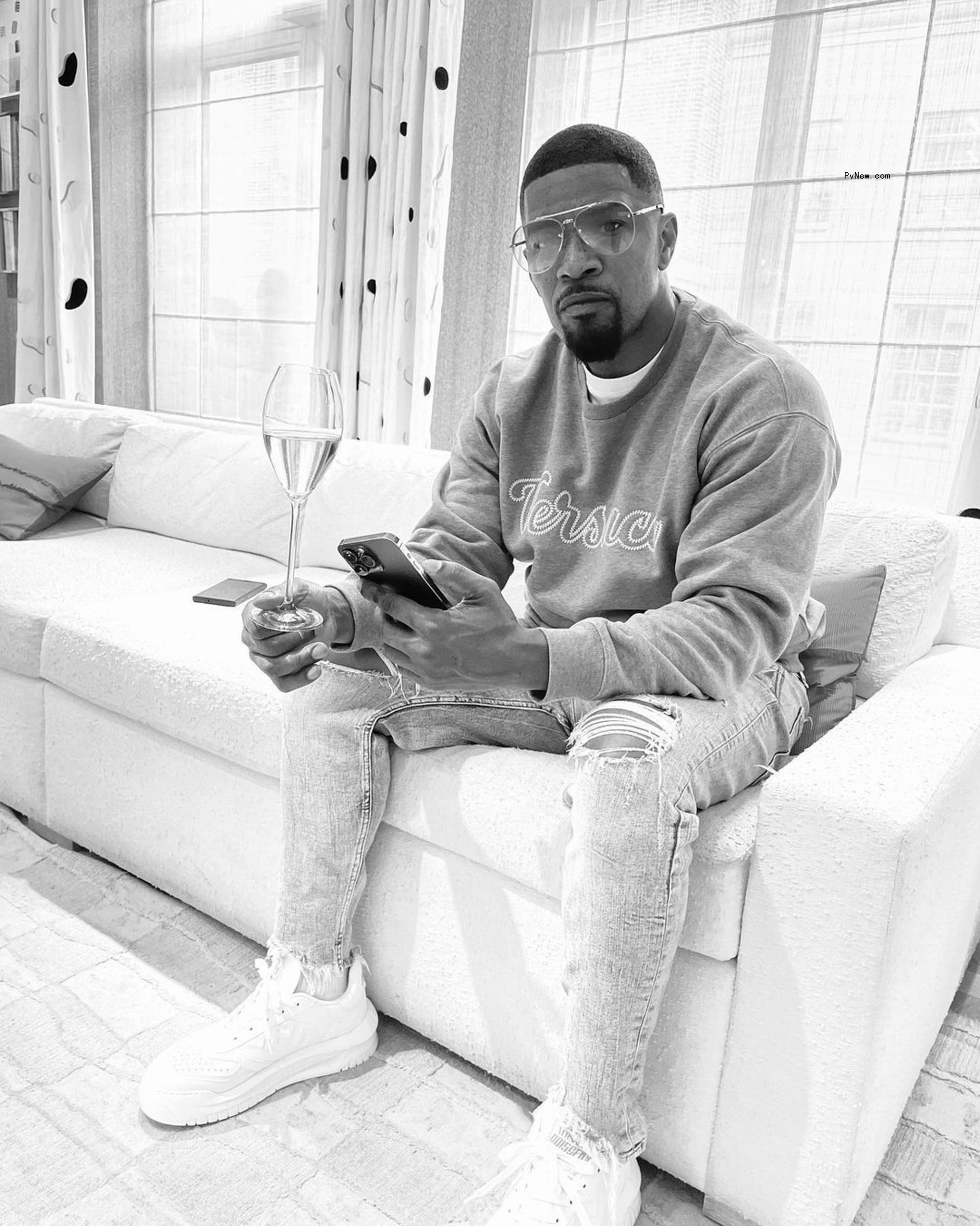 Jamie Foxx sitting down on a couch in a black-and-white photo.