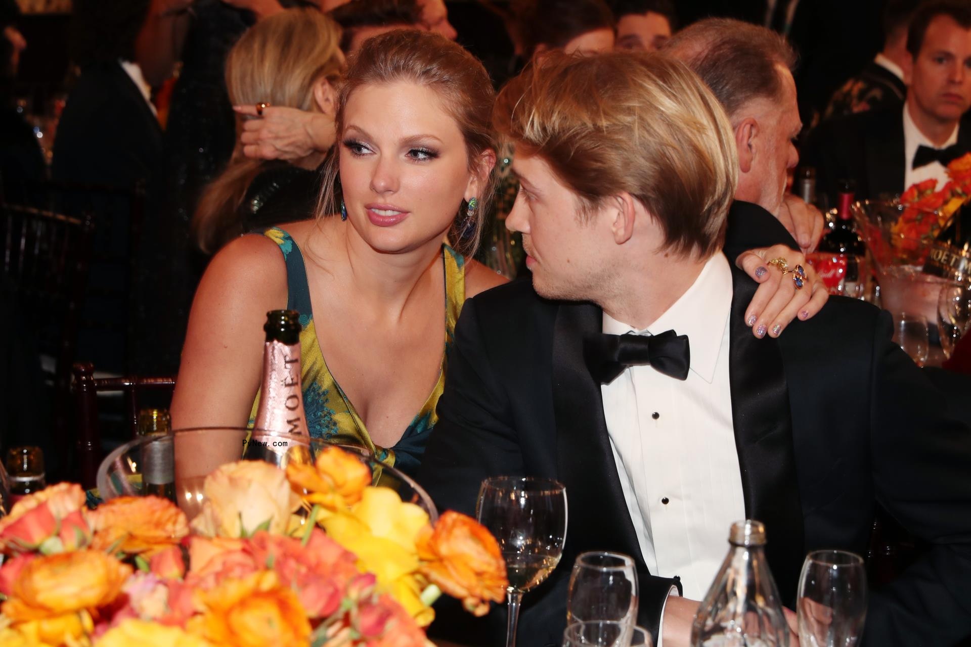 Joe Alwyn and Taylor Swift sitting together at an event.
