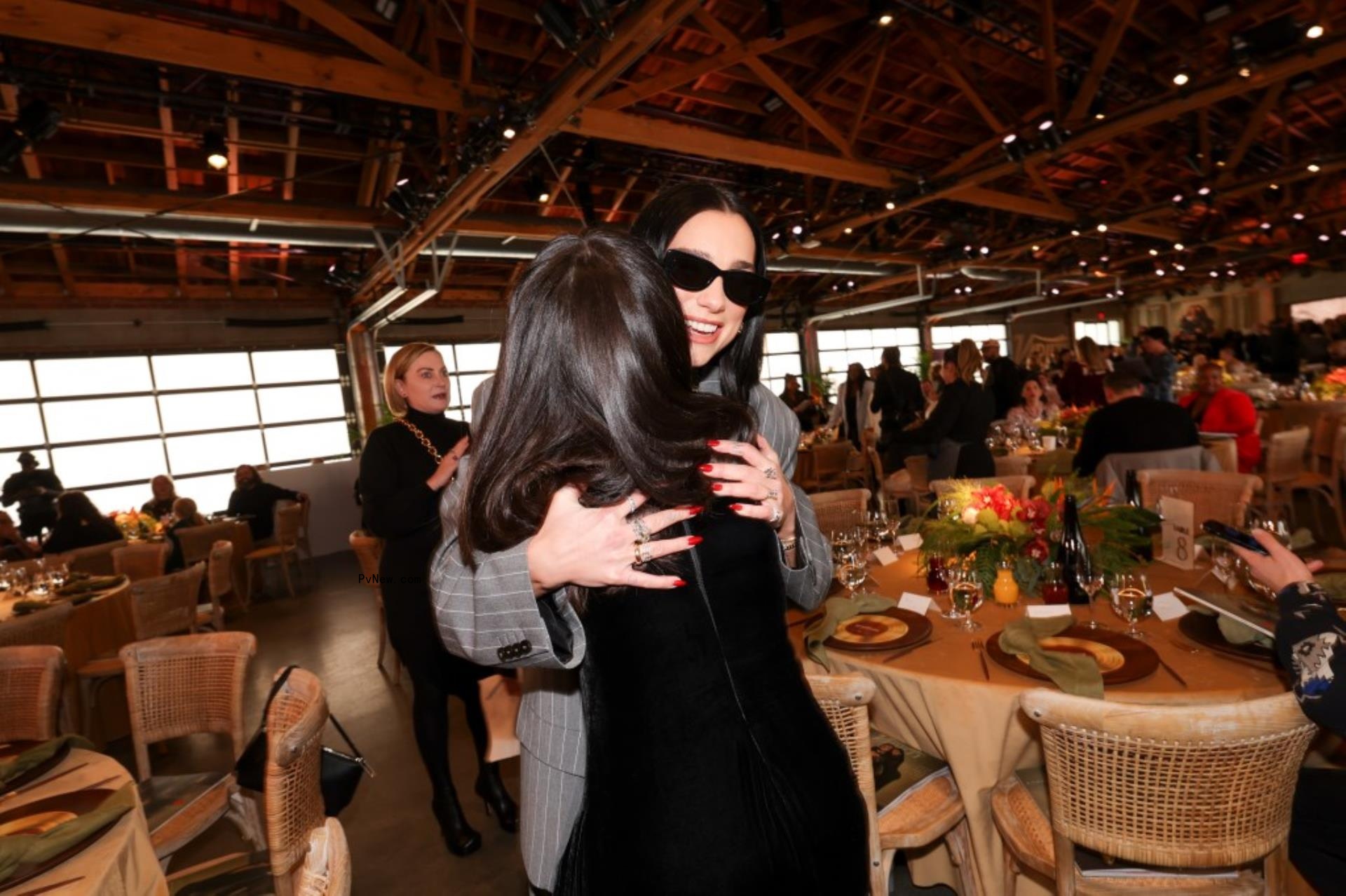 Dua Lipa and Selena Gomez hugging at a formal event