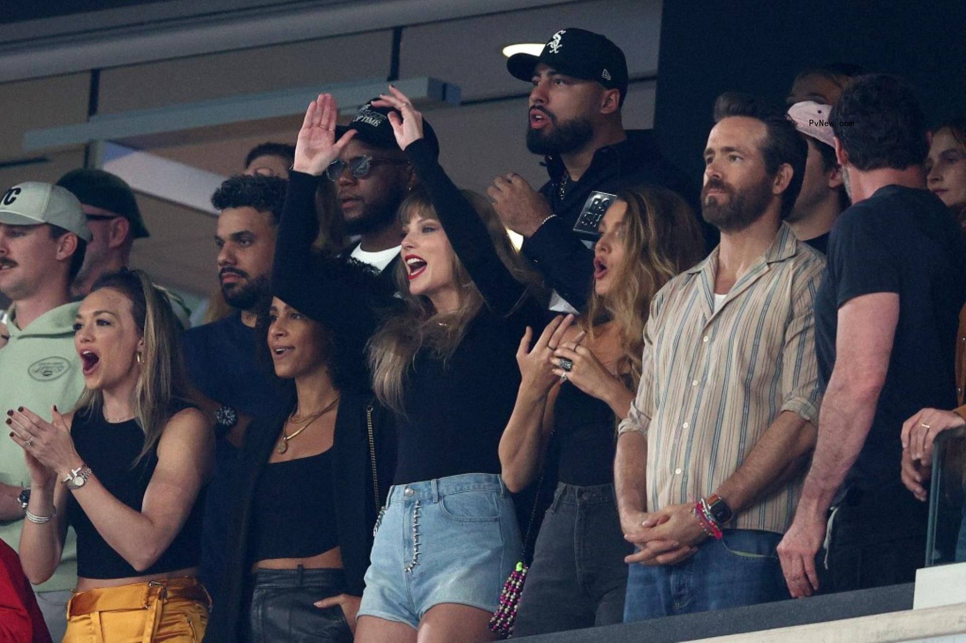 taylor swift, blake lively, ryan reynolds cheering in a stadium box