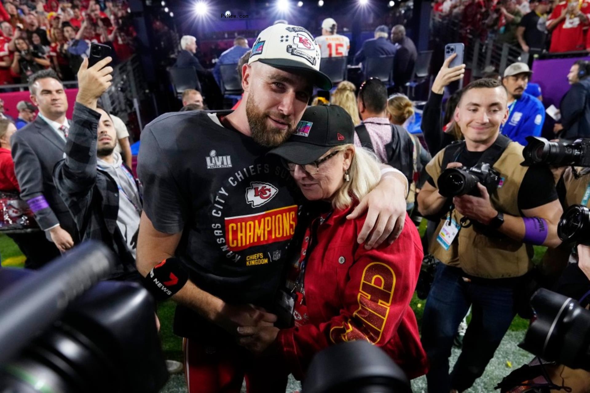travis kelce hugging his mom, do<i></i>nna kelce, surrounded by reporters